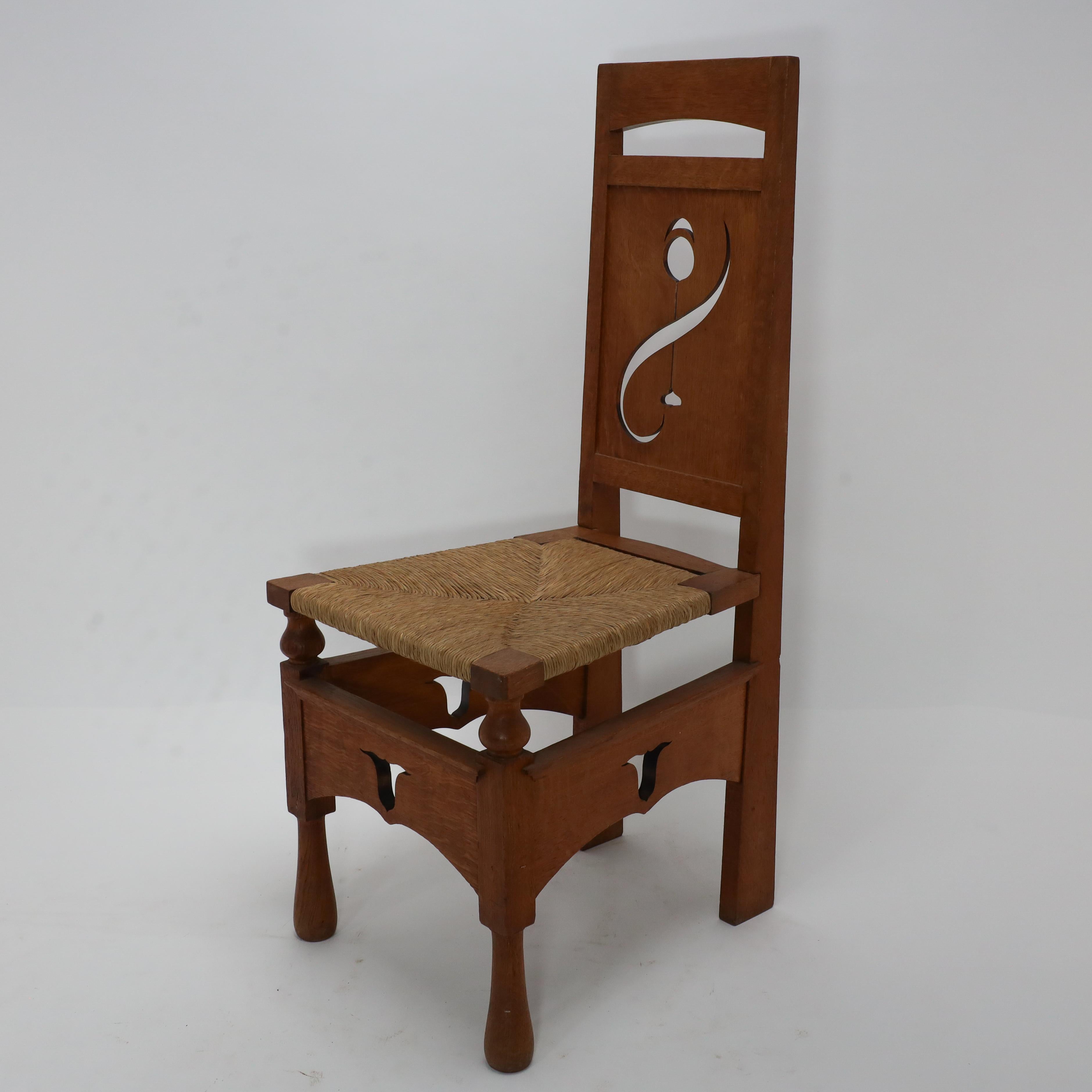 Arts and Crafts Une chaise en chêne attribué M H Baillie Scott Arts & Crafts avec des découpes florales stylisées en vente