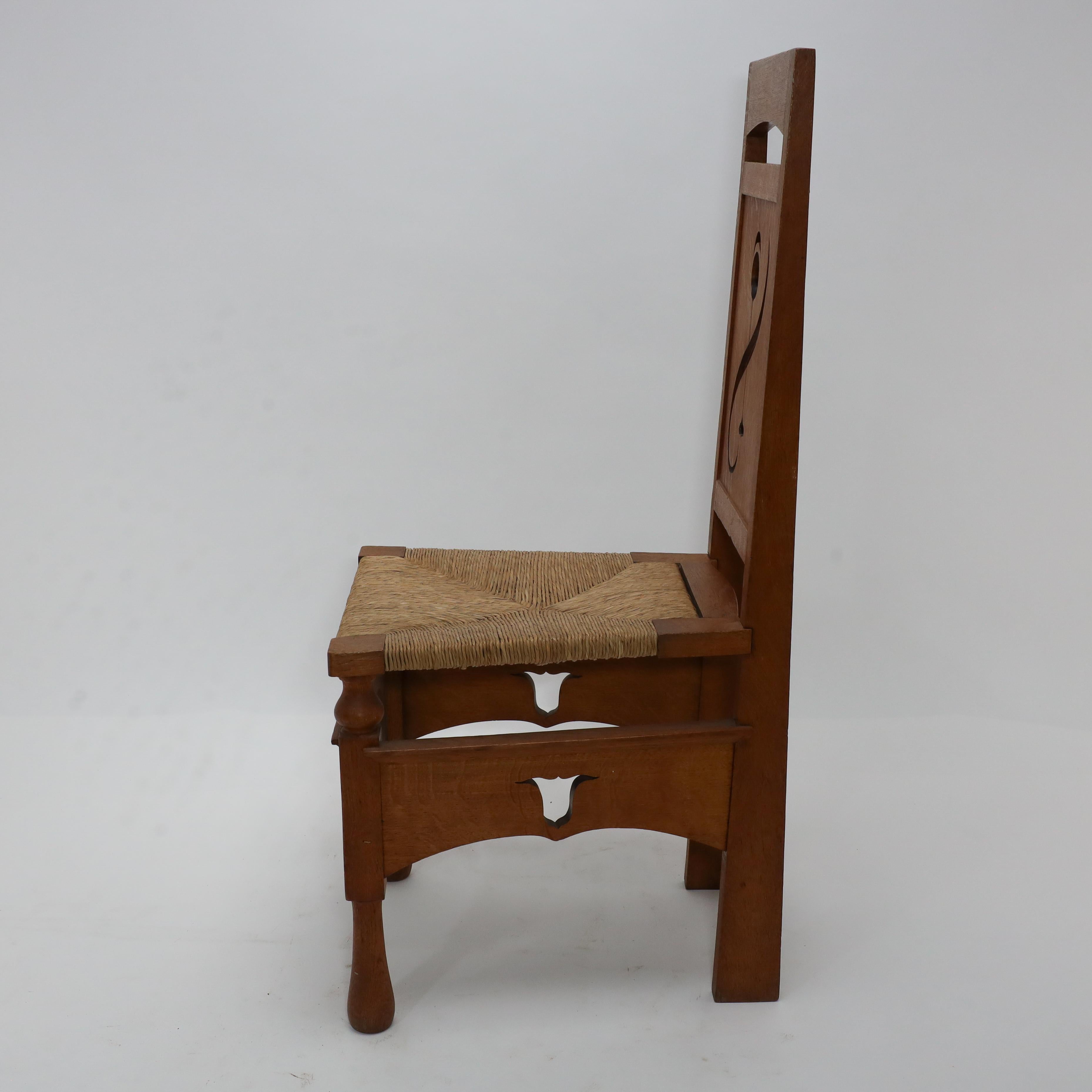 Anglais Une chaise en chêne attribué M H Baillie Scott Arts & Crafts avec des découpes florales stylisées en vente