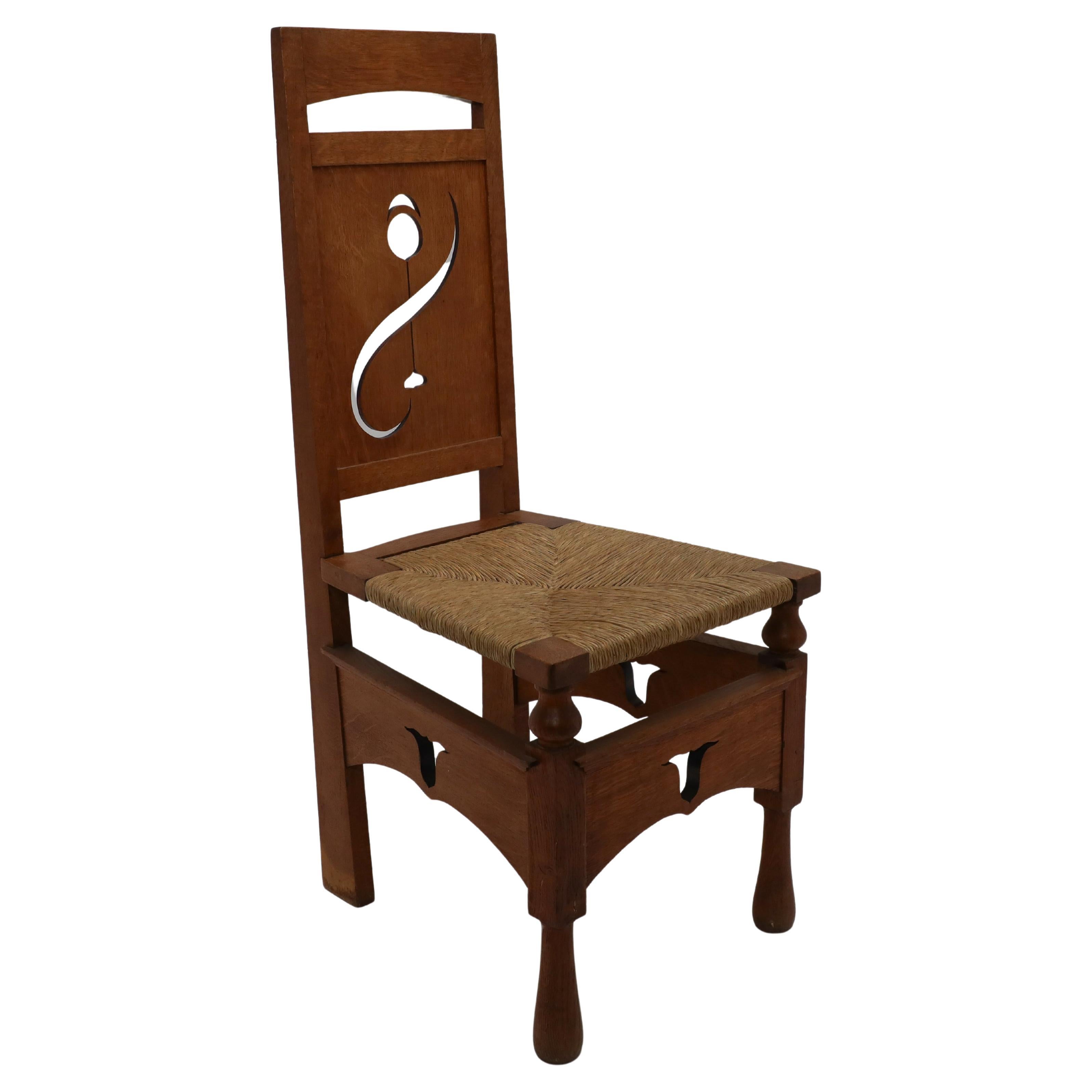 M H Baillie Scott attri An Arts & Crafts Oak Chair With Stylised Floral Cut-Outs