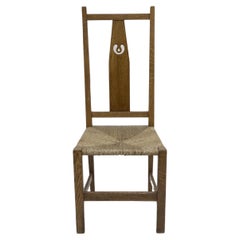 M H Baillie Scott attributed. An Arts & Crafts oak chair with pierced decoration