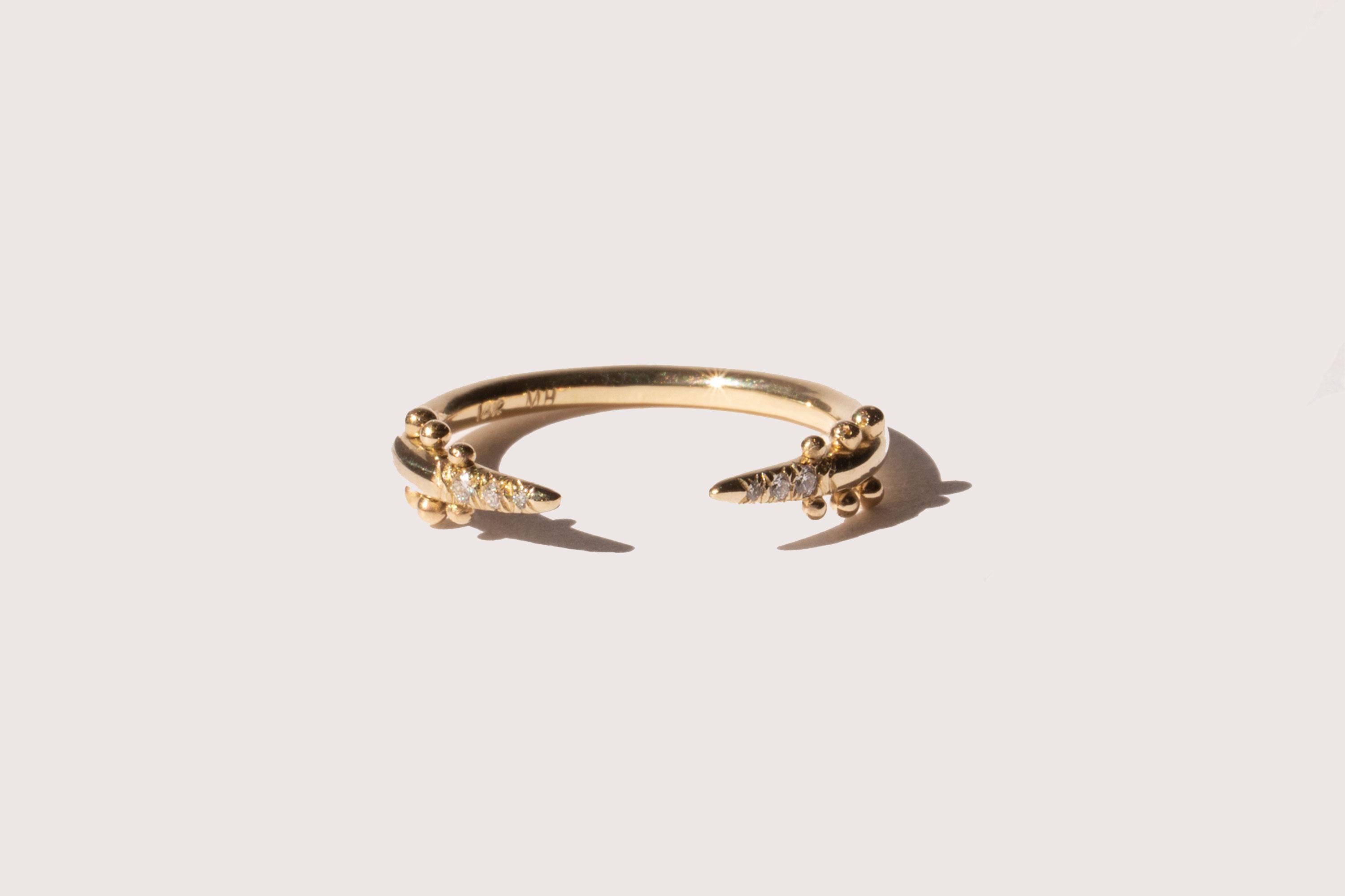 A diamond-encrusted, tapered point ring with signature M. Hisae bead detailing. This piece is feminine fierceness. To create it, we took the Maya Ring, opened up the center, moved the beads to the exterior, and added teensy diamonds to the soft