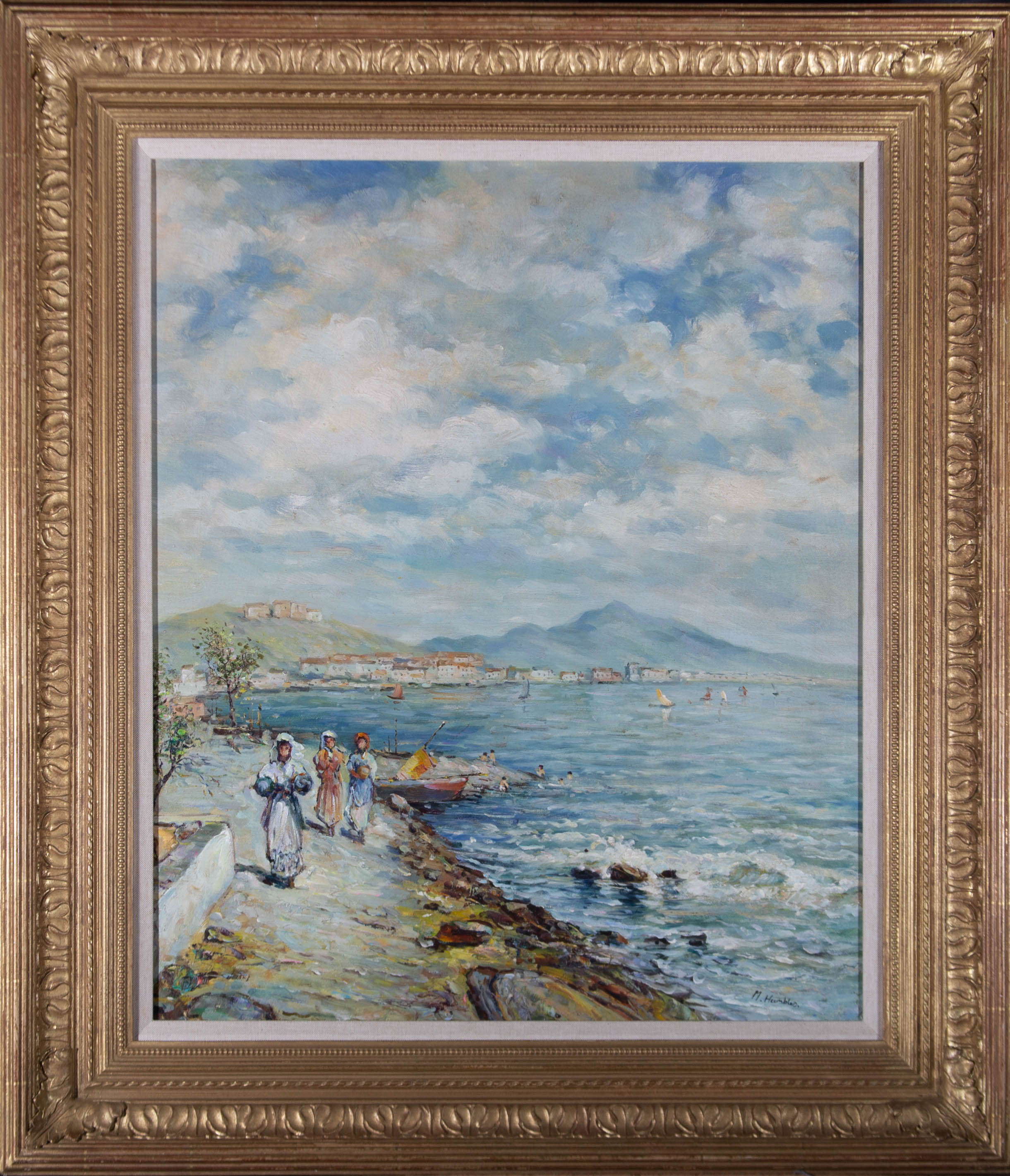 A fine continental coastal scene featuring figures walking along the waterside, sailing boats on the water, and a town and mountain visible on the opposite bank. Very well-presented in an ornate gilt frame with a reeded outer edge and acanthus leaf
