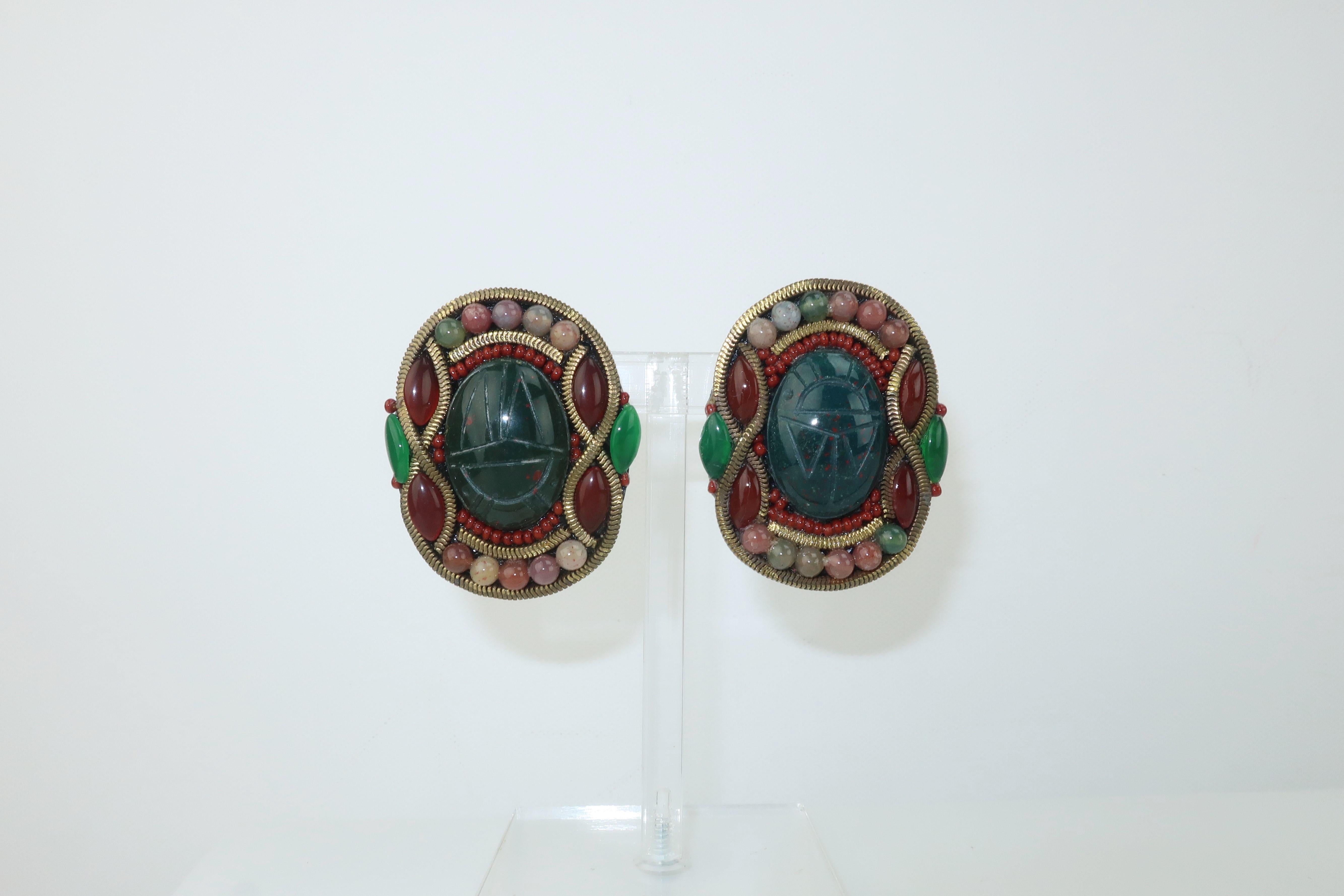 These exotically styled earrings from M & J Hansen are a black resin base accented by dark green carved stone scarabs surrounded by glass beads replicating rose quartz and carnelian.  A textured chain border adds to the design which is reminiscent