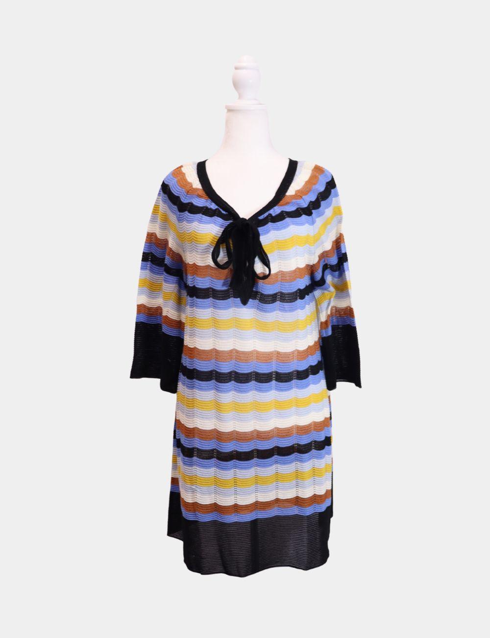 Bold, playful, and unmistakably Missoni—this M Missoni multicolor knit dress showcases the brand's signature zigzag stripe in a relaxed silhouette. Crafted in a lightweight open-knit fabric, it features a flattering V-neckline with a soft black bow