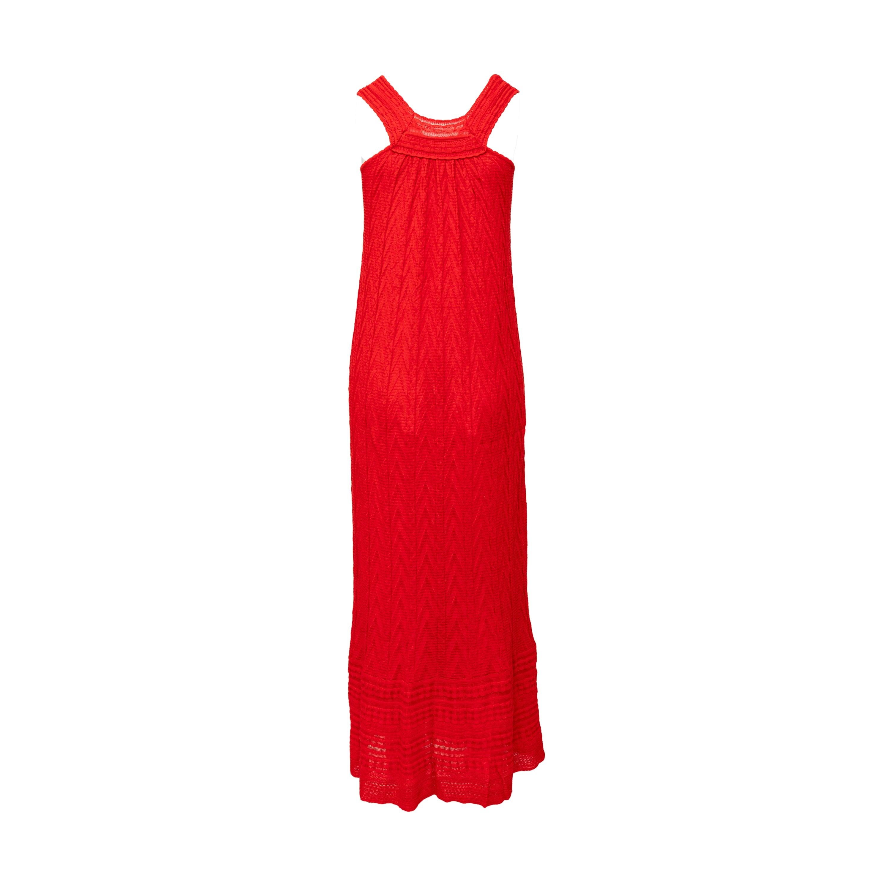 Este maxivestido Missoni de la marca M presenta su característico estampado de galones en un tejido elástico de color rojo. El diseño sin mangas y el escote redondo hacen que este vestido sea a la vez cómodo y elegante. Perfecto como atuendo de