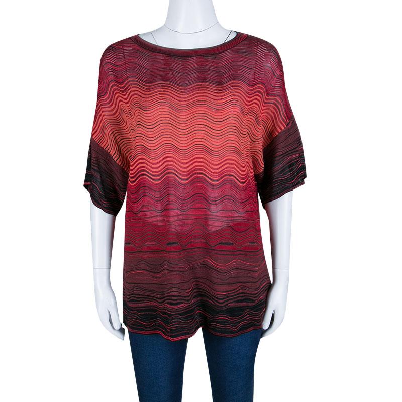 Oversized top is in fashion and to add a classy touch to it M Missoni has crafted a beautiful piece. It has a simple round neckline and short sleeves along with wave pattern all over. This multicolored top will go finely with a tight pair of