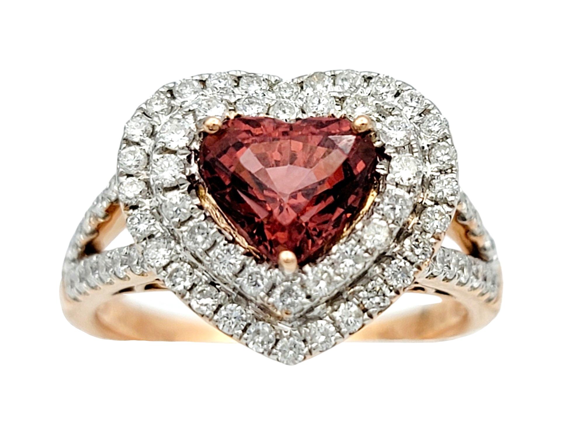 Ring Size: 7.25

This enchanting ring features a heart-shaped spinel as its focal point, exuding warmth and romance, set within lustrous 14 karat rose gold. The vivid brownish-red hue of the spinel is enhanced by a dazzling double halo of sparkling
