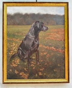 Englisches Porträt eines sitzenden schwarzen Labradorhundes in einer Landschaft
