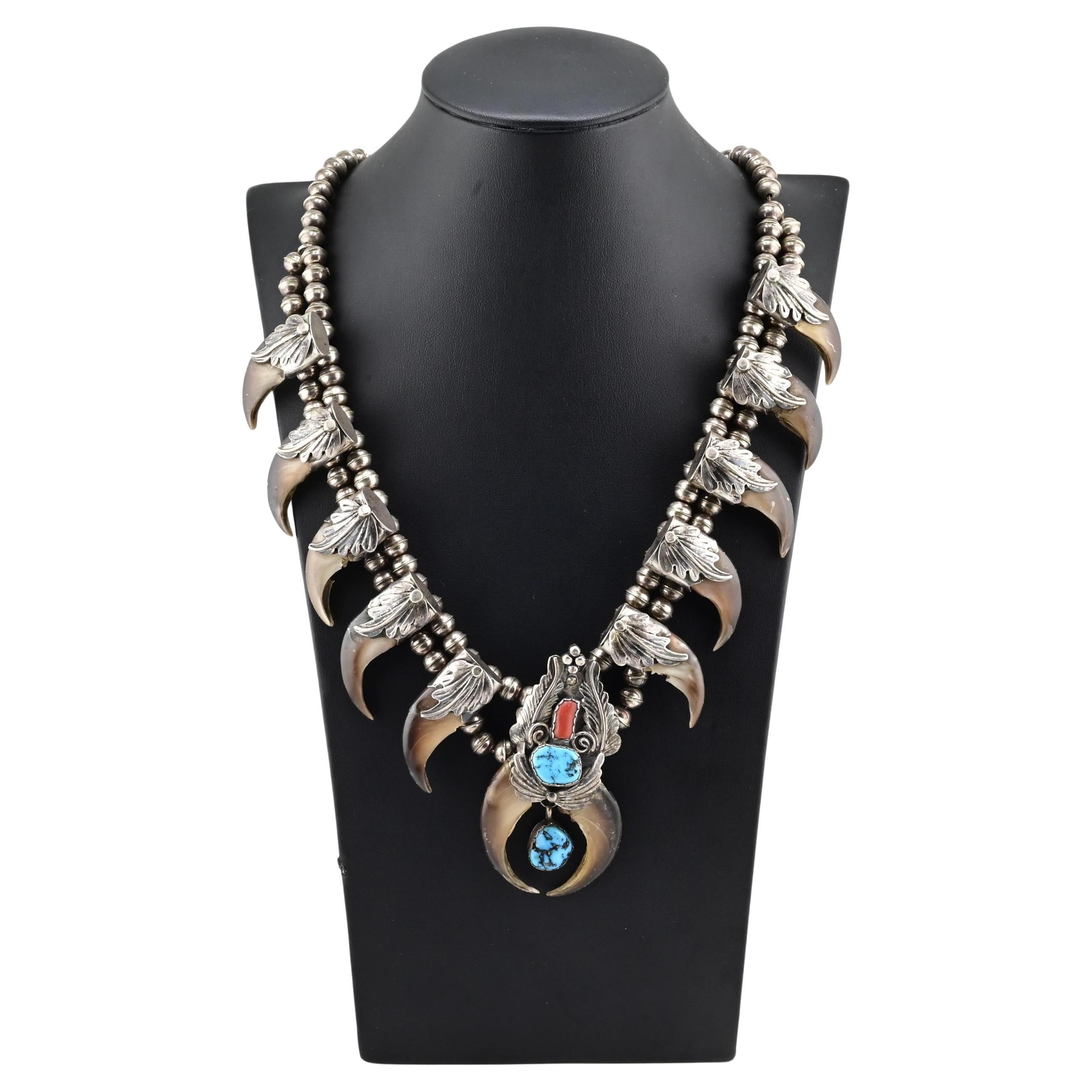 In offerta c'è una splendida collana in argento sterling dei nativi americani Navajo realizzata a mano da M. Tsosie, con un motivo tradizionale a forma di artiglio d'orso incastonato con pietre di turchese e corallo.
Questo imponente pezzo misura