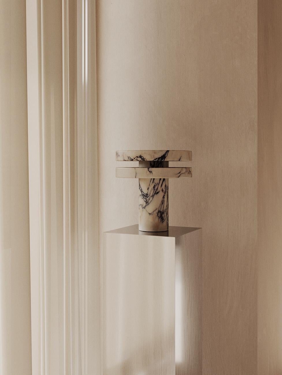 Die M_014 Tischleuchte wird von Hand aus einem schönen Block Calacatta Viola Marmor geschnitzt. Sein brutalistisches Design ist sowohl skulptural als auch kraftvoll. Sie wird von einer warmen 2700k-LED-Leiste betrieben, die im Sockel der Lampe