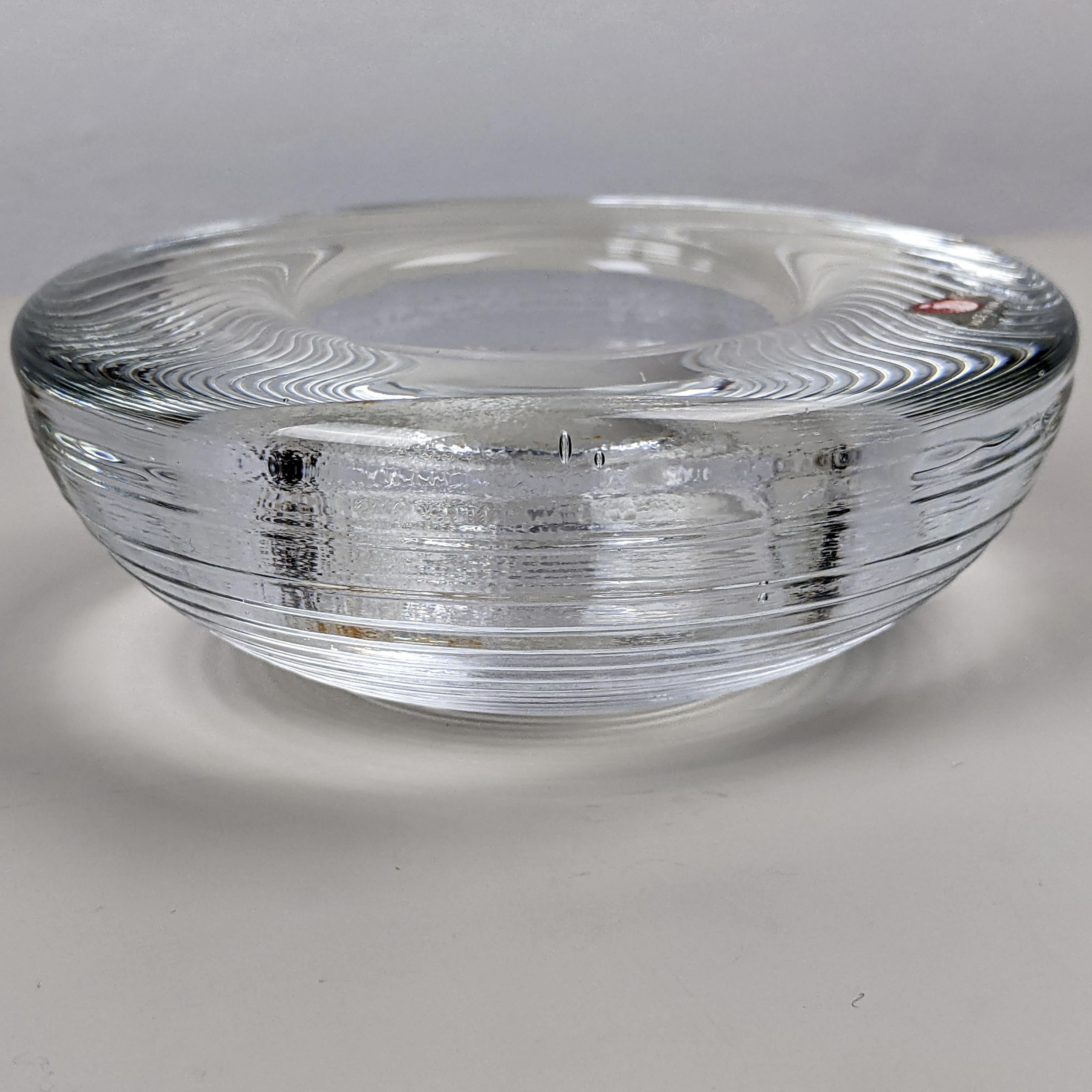 Tapio Wirkkala for Iittala, c. 1970
‘Maaru’ candle tealight holder

Clear glass
Good condition. Some very light staining to inside (from tealight)

Dimensions, approx..:
diam. 11cm, h 4.5cm, weight 575g.