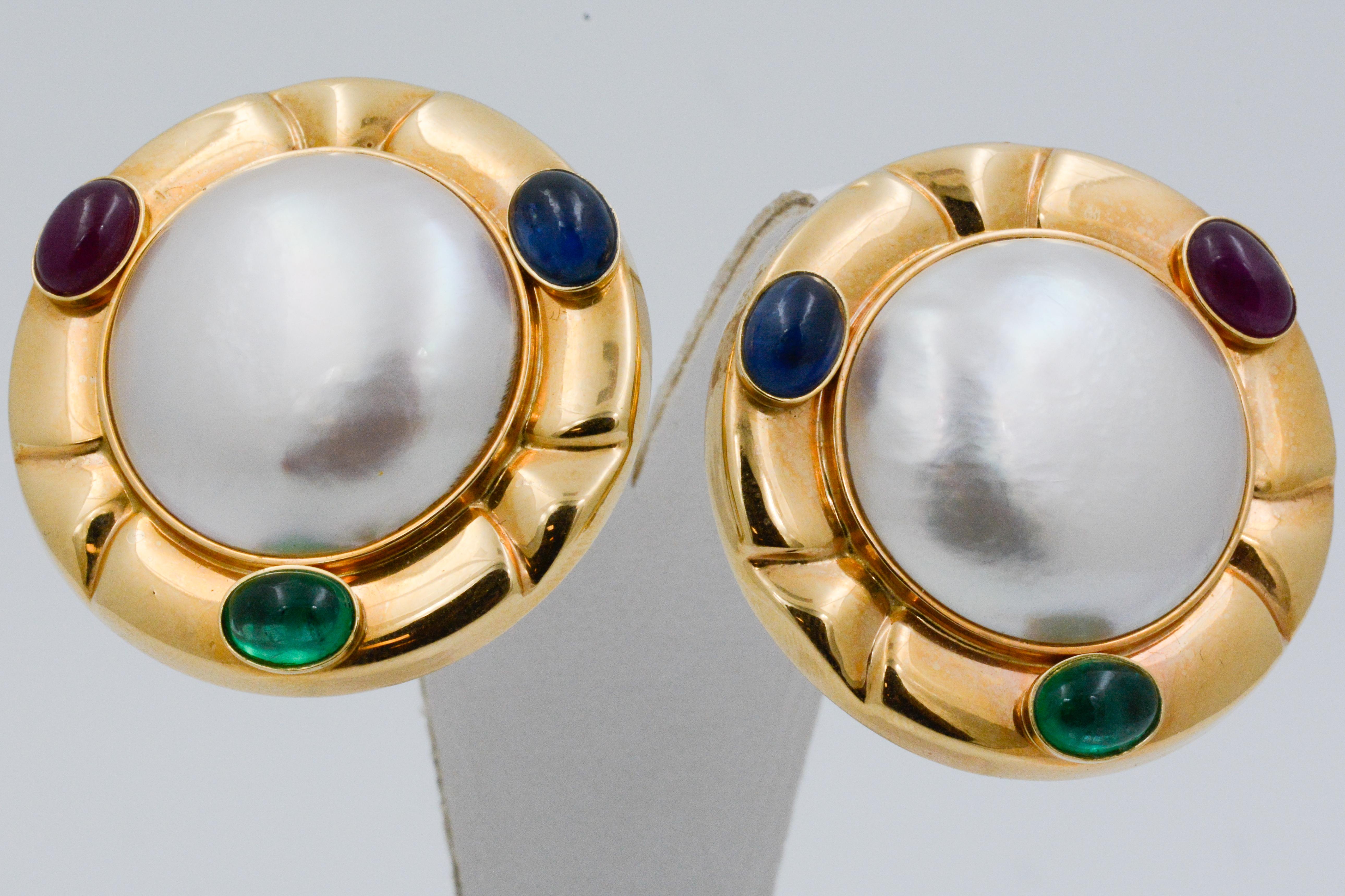  Shiny 14 karat yellow surrounds a large Mabe' pearl is set with one cabochon cut blue sapphire, one cabochon cut ruby and one cabochon cut emerald. 