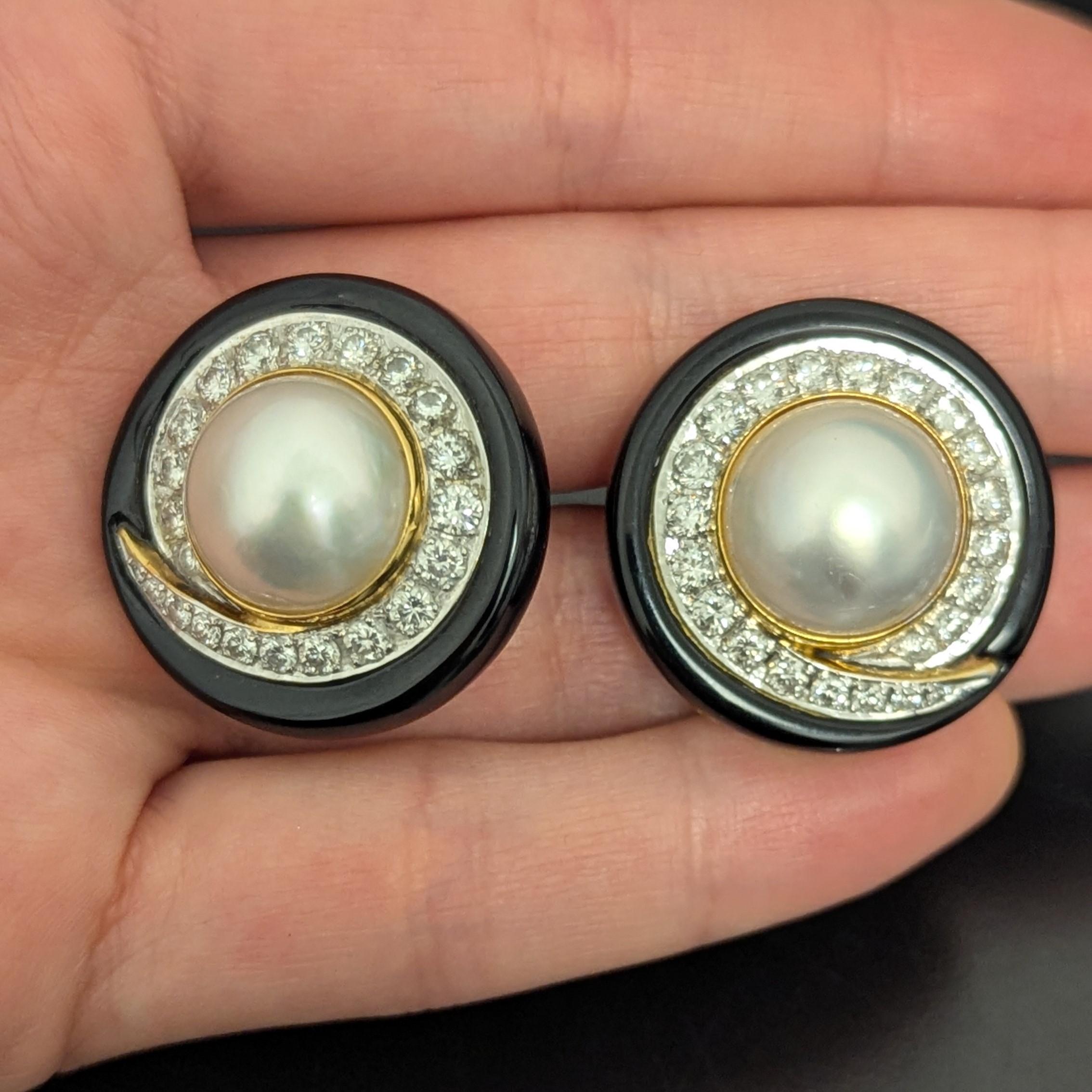 Questi orecchini dal design unico e meraviglioso sono caratterizzati da perle mabé di 14,0 mm ciascuna, circondate da oro giallo, 44 diamanti rotondi del peso di circa 2,50 carati e onice nera, il tutto incastonato in oro giallo e bianco 18 carati.