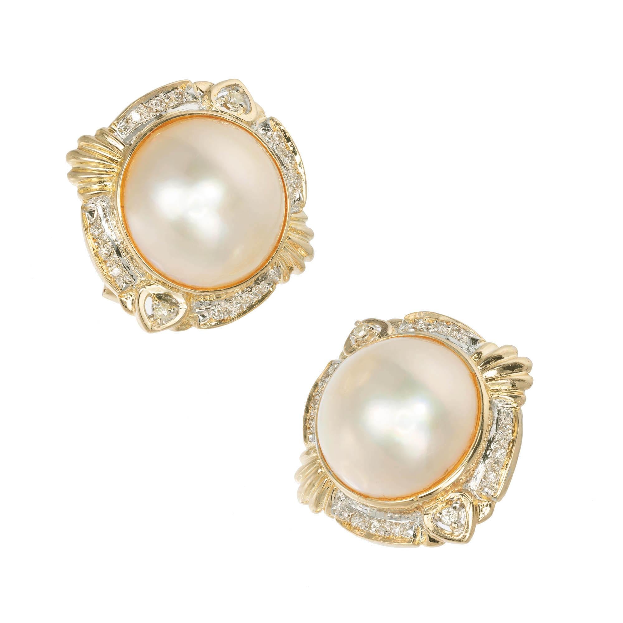 14k Mobe Pearl and Diamond earrings crème colored Mobe Pearl with a rose hue set in 14k yellow gold setting with round Diamonds Pavé set in four parts scalloped edge in two parts with prong set Diamonds in the other 2 parts.

2 Mobe Pearls,