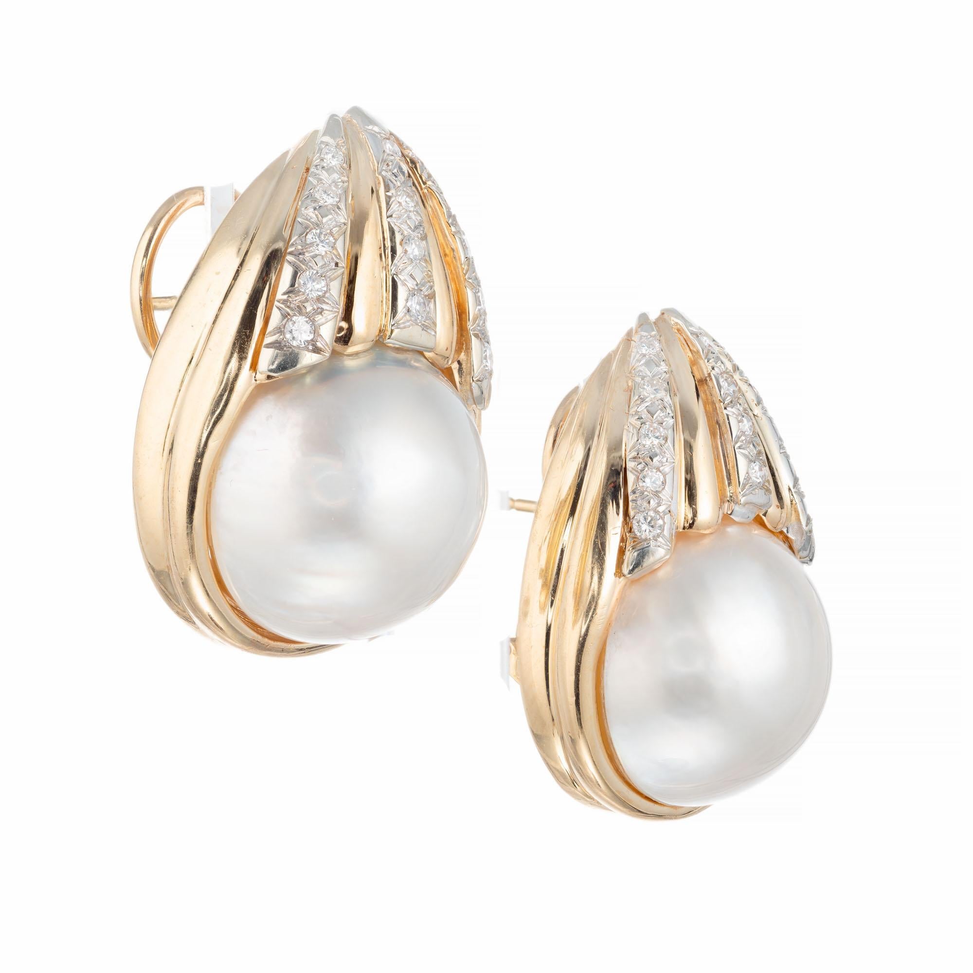 Mabe pearl and diamond earrings. 2 large cabochon set mabe pearls with 28 round accent diamonds in 14k yellow gold settings. 

2 mabe pearls approx. 17mm each. 
28 round diamonds, approx total weight: .20cts H, SI
Length: 1.16 inches or