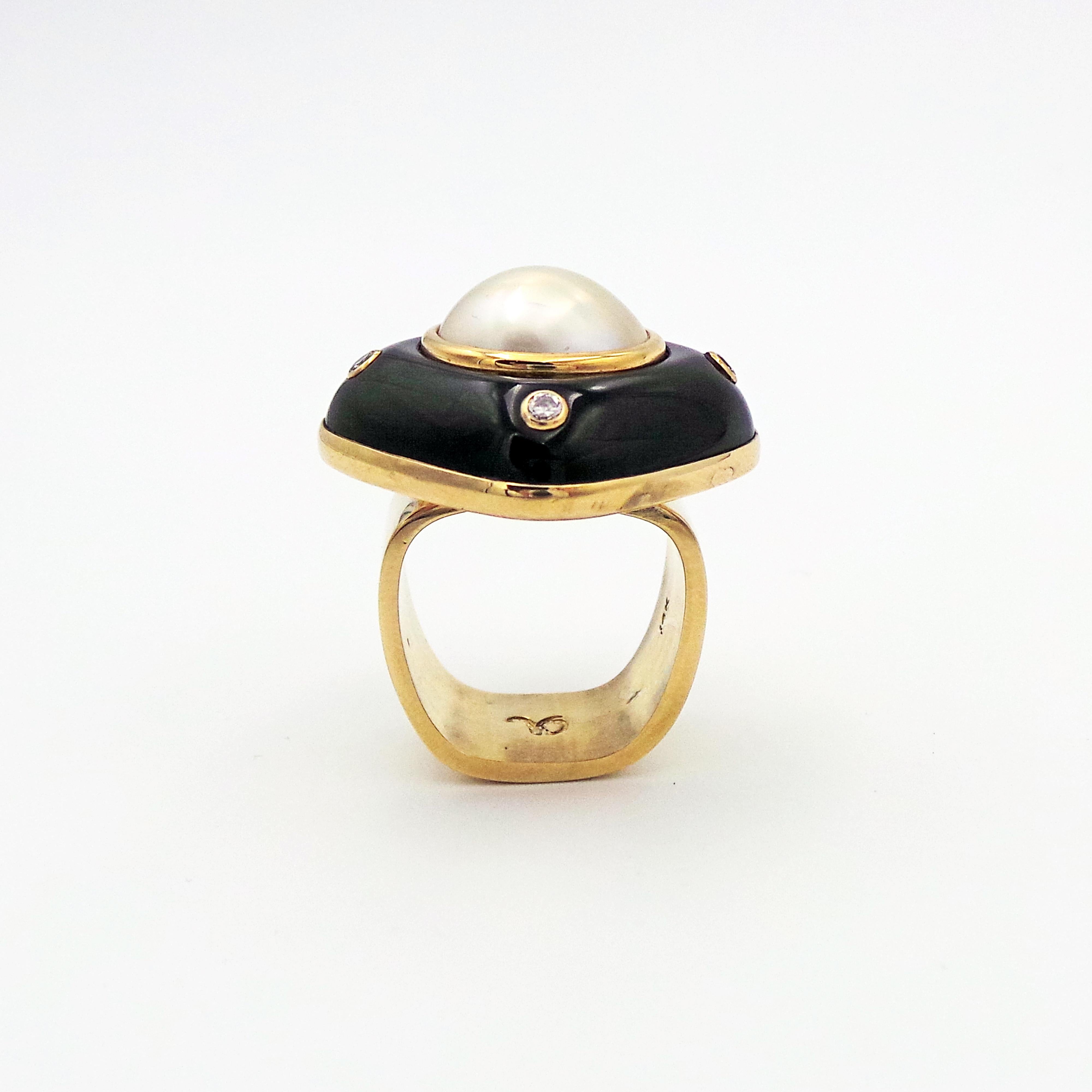 Modern meets retro is this Mabe Pearl, carved Onyx, and accent diamonds (total weight 0.10 carats, SI1 clarity, H-I color) set in 14k yellow gold, and mounted onto a solid 14k yellow gold square band. Size 7. 