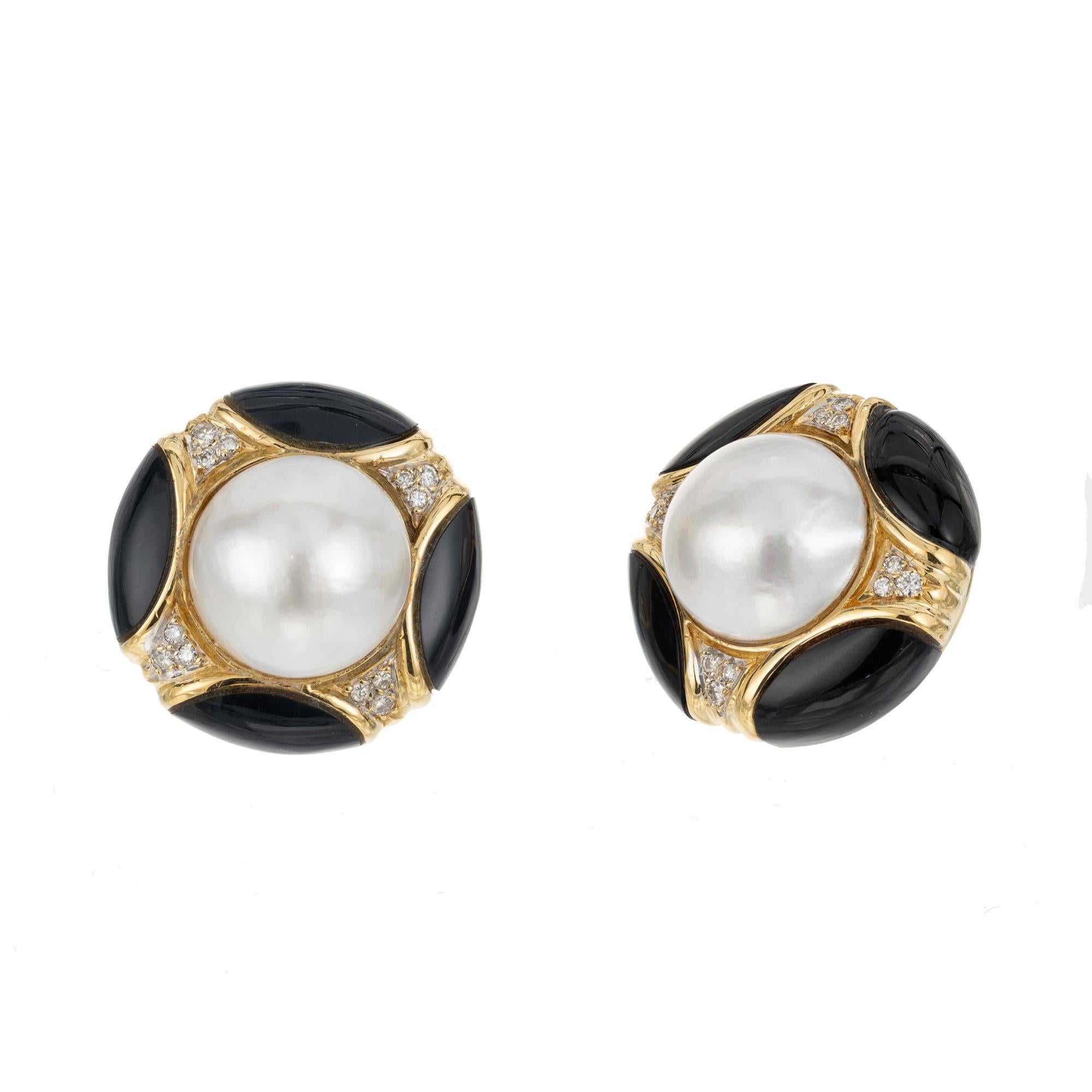 1960's domed button style clip post earrings. Both are mounted with a cabochon Mabe domed pearl accented by clusters of round cut diamonds totaling .28cts. These mid-century classics are rounded out with 4 fitted pieces of well-polished Onyx. 

2