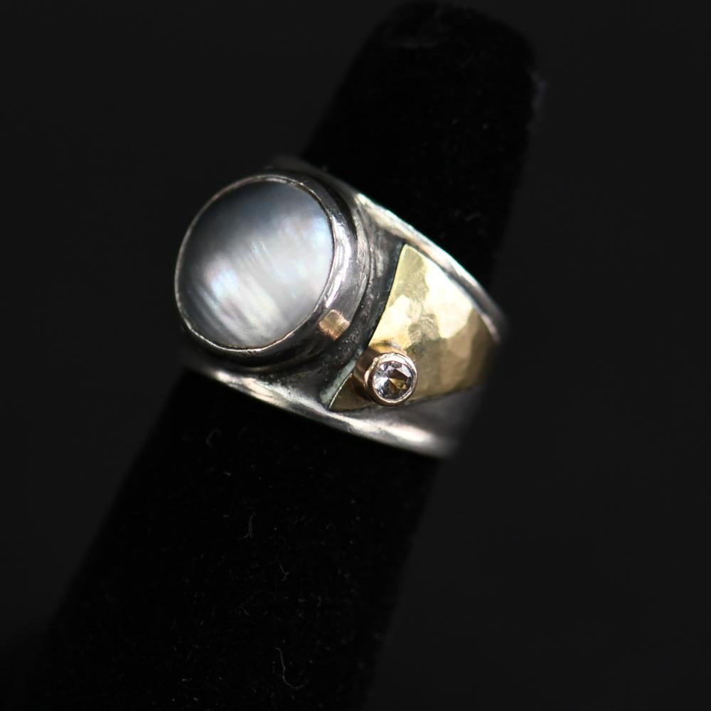 Artist-signed illegibly on band. Sterling silver and 14-karat gold.
Ring size: 5.5.
