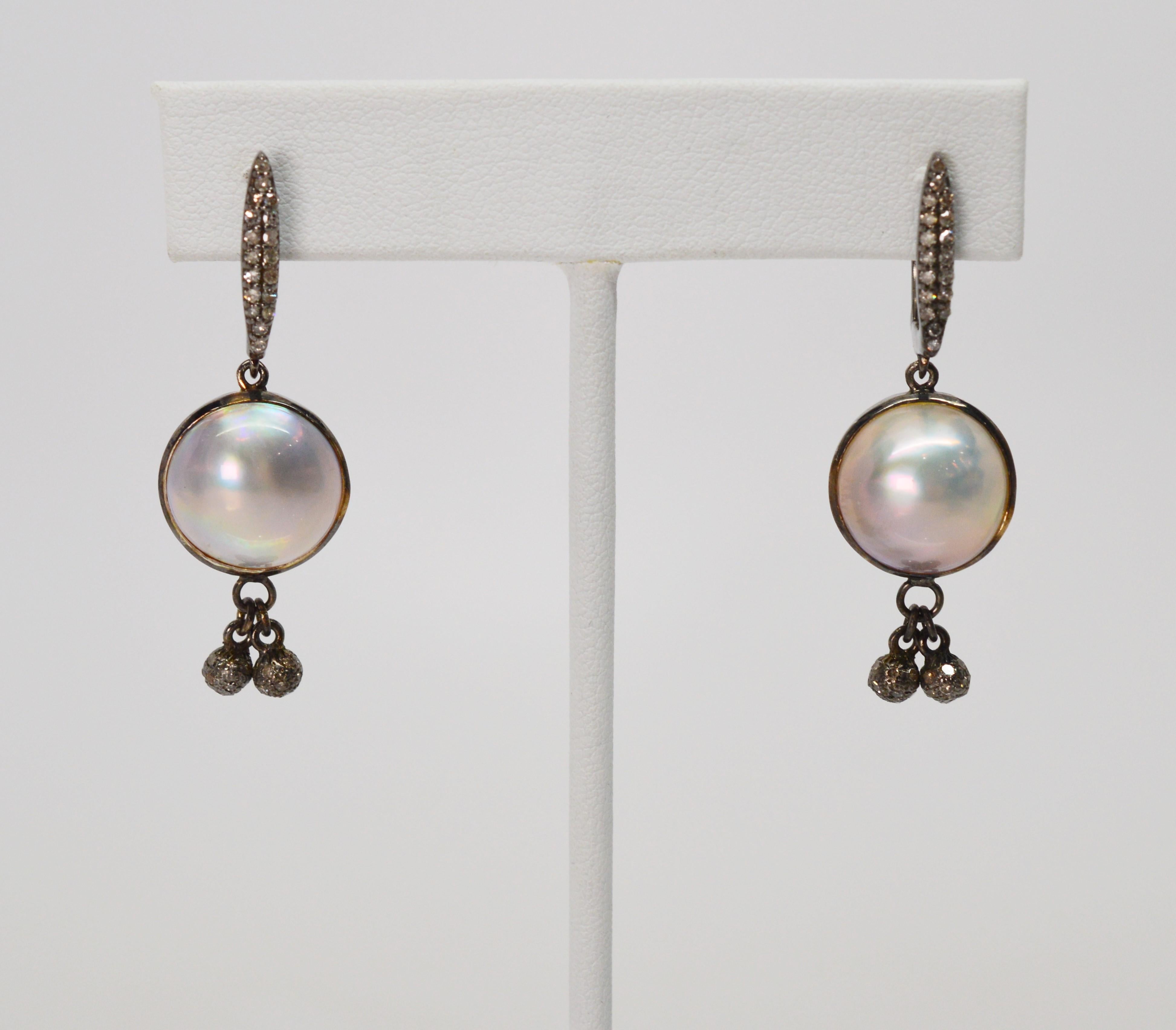 Beautiful mabe pearls are suspended from fancy sterling silver and diamond vertical clips for pierced ears. Tiny silver and diamond spheres add further sparkle and accent the center 13mm pearl. The earring drop is 1-1/2 inch from post. In gift box.
