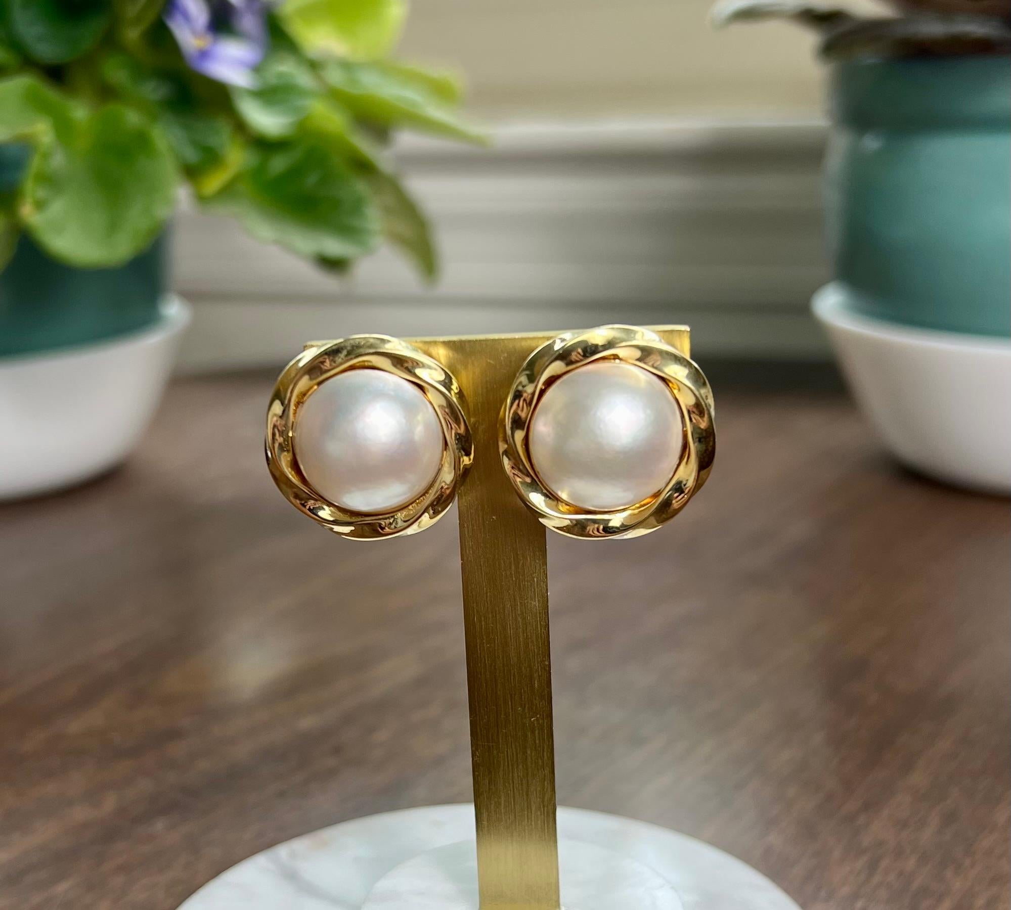 One pair of mabe pearl earrings measuring 23.16mm set in 18 karat yellow gold complete with Omega back closures.  The earrings weigh 25.3 grams in total.  