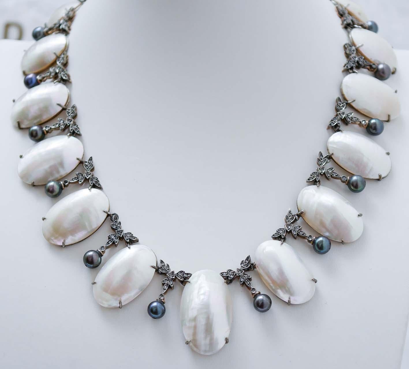 Retrò necklace in 9 kt rose gold and silver structure mounted with mabé pearls and, between of them, structure studded with diamonds and, below, a grey pearl.
This necklace was totally handmade by Italian master goldsmiths and it is in perfect