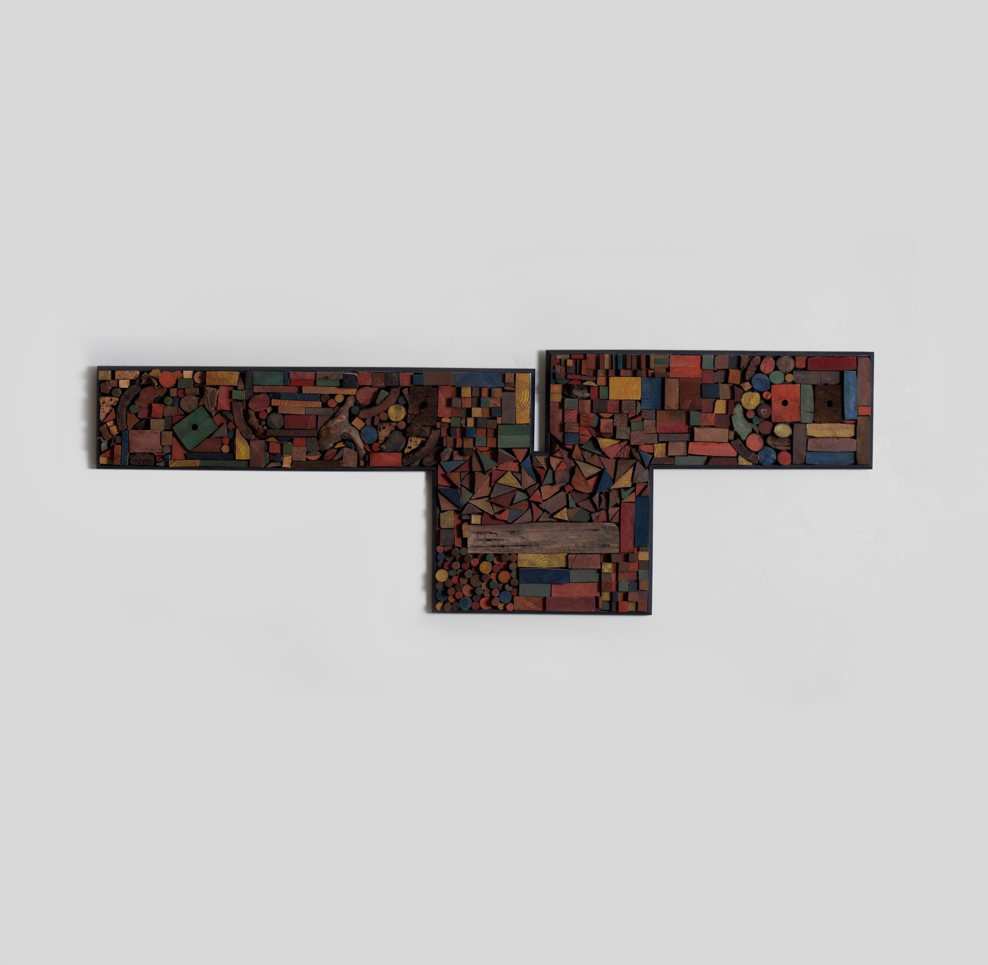 Mosaic wood assemblage in the style of Mabel Hutchinson. This large scale wall piece features a mix of earth tone and bright primary colored wood shapes inlayed to a wood frame. The framed pieces are irregularly cut and tightly arranged into a