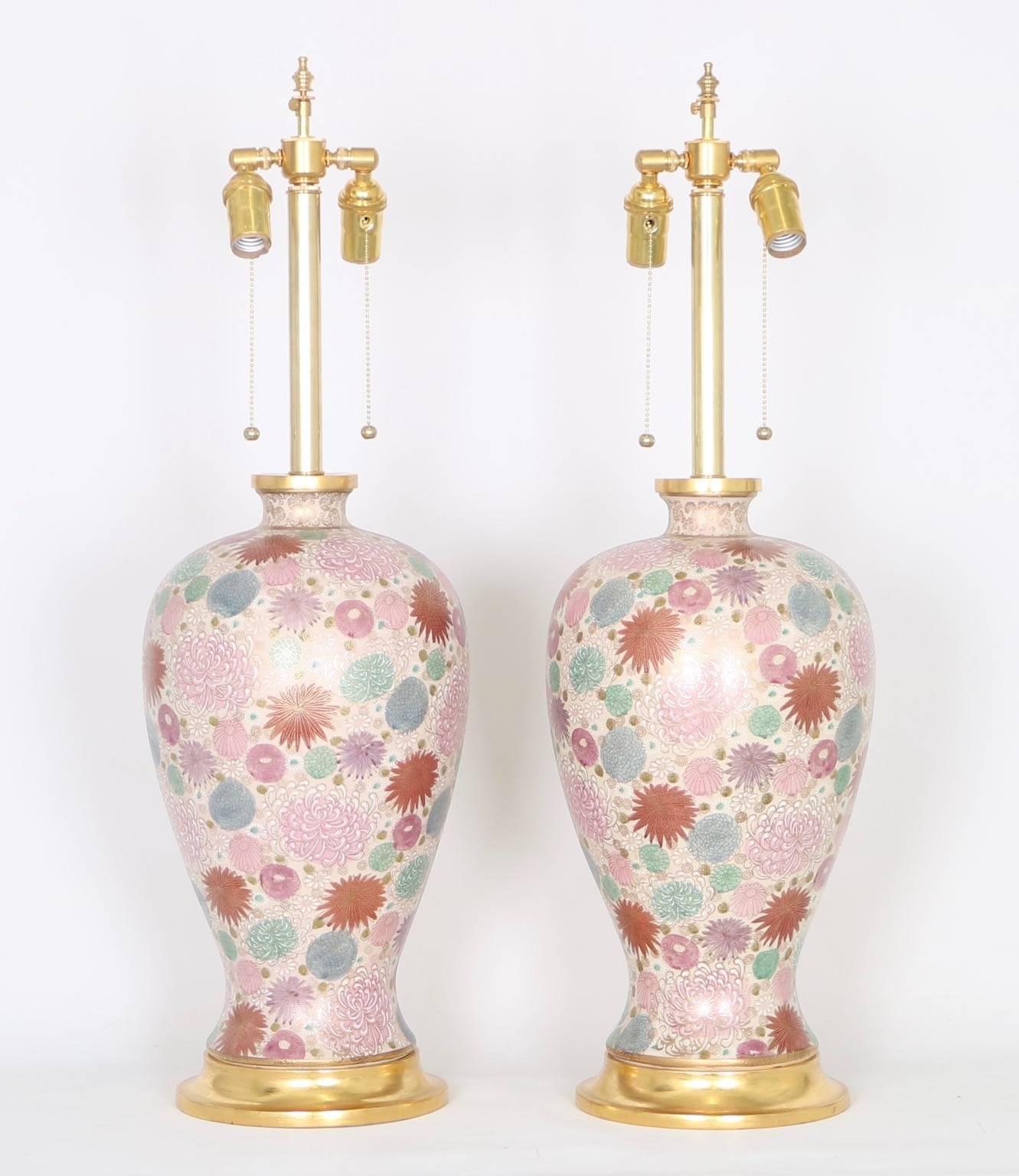 Hollywood Regency Japanese vase table lamps with a chrysanthemum motif in soft pink, mauve, mint, violet and powder blue hues mounted on gilded bases by Mabro. The lamps have been fully restored with all new wiring and hardware including a double