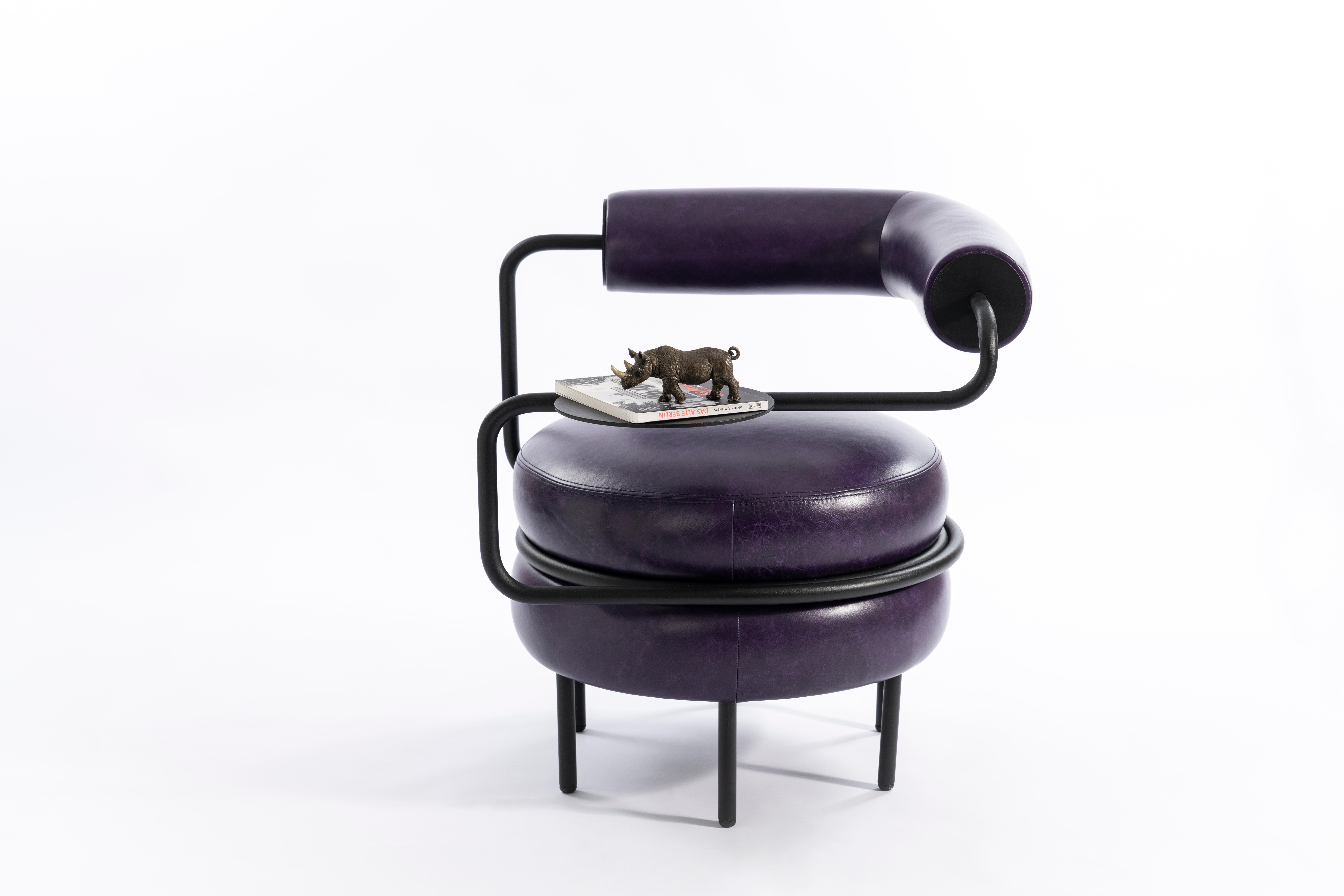 Kontra's interpretation of Macaron. Comfortable purple armchair.
One-armed leather chair provides comfortable seating with a side table of its own.