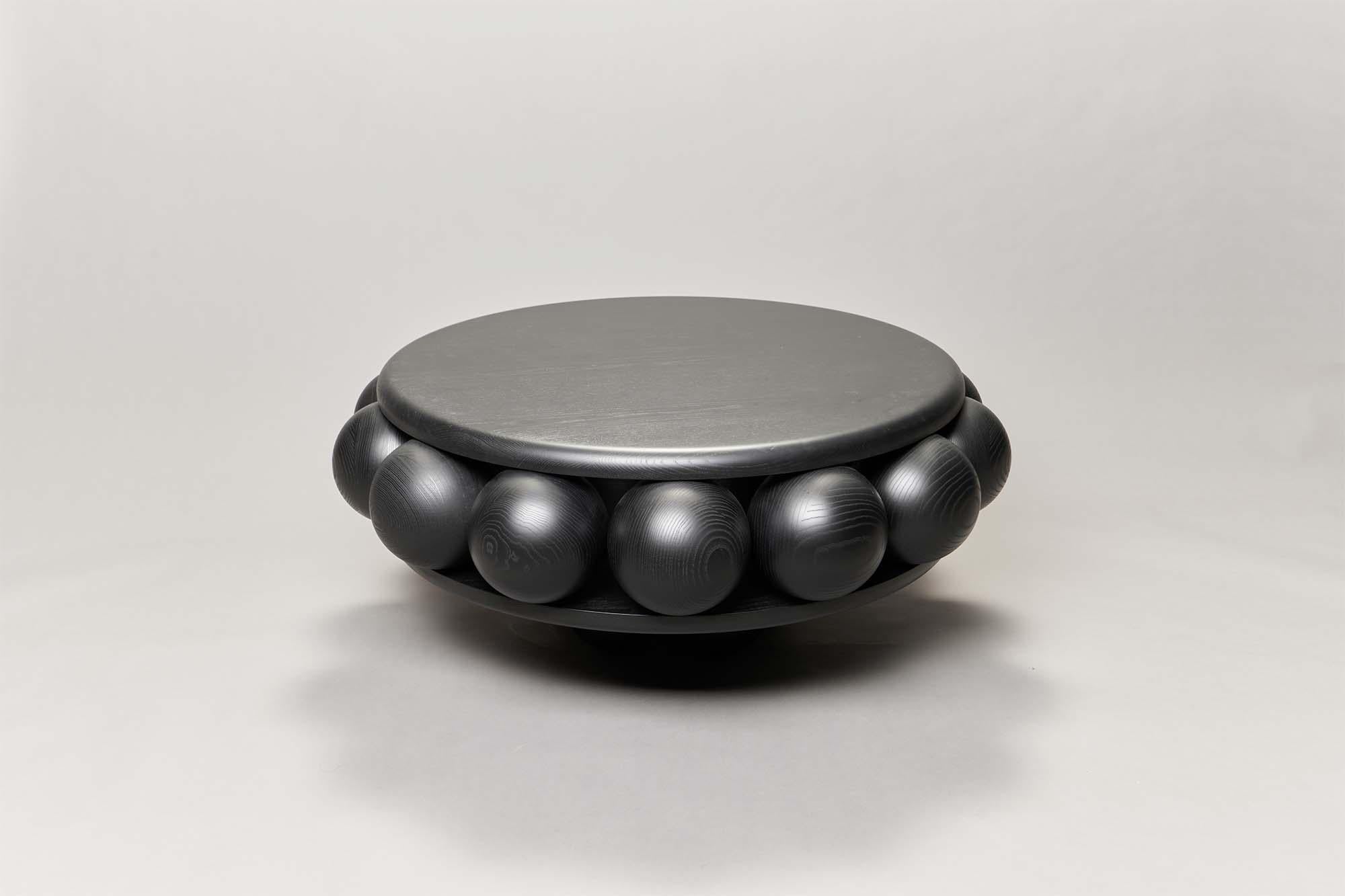 Macaroon coffee table utilises fourteen spheres like berries, sandwiched between two round plates and made of 3D milled stained ash, available in either black ,white or natural finish.