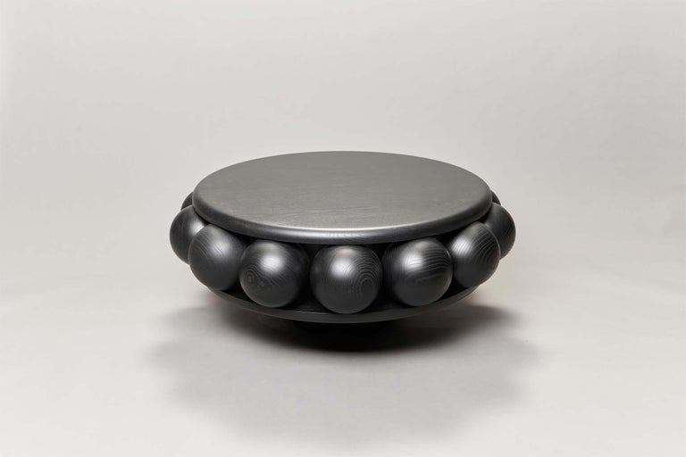 Macaroon coffee table utilises fourteen spheres like berries, sandwiched between two round plates and made of 3D milled stained ash, available in either black or white.