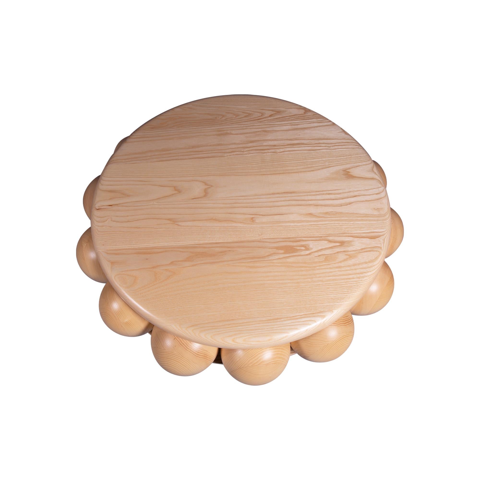 Macaroon coffee table utilises fourteen spheres like berries, sandwiched between two round plates and made of 3D milled stained ash, available in either black, white or natural finish.