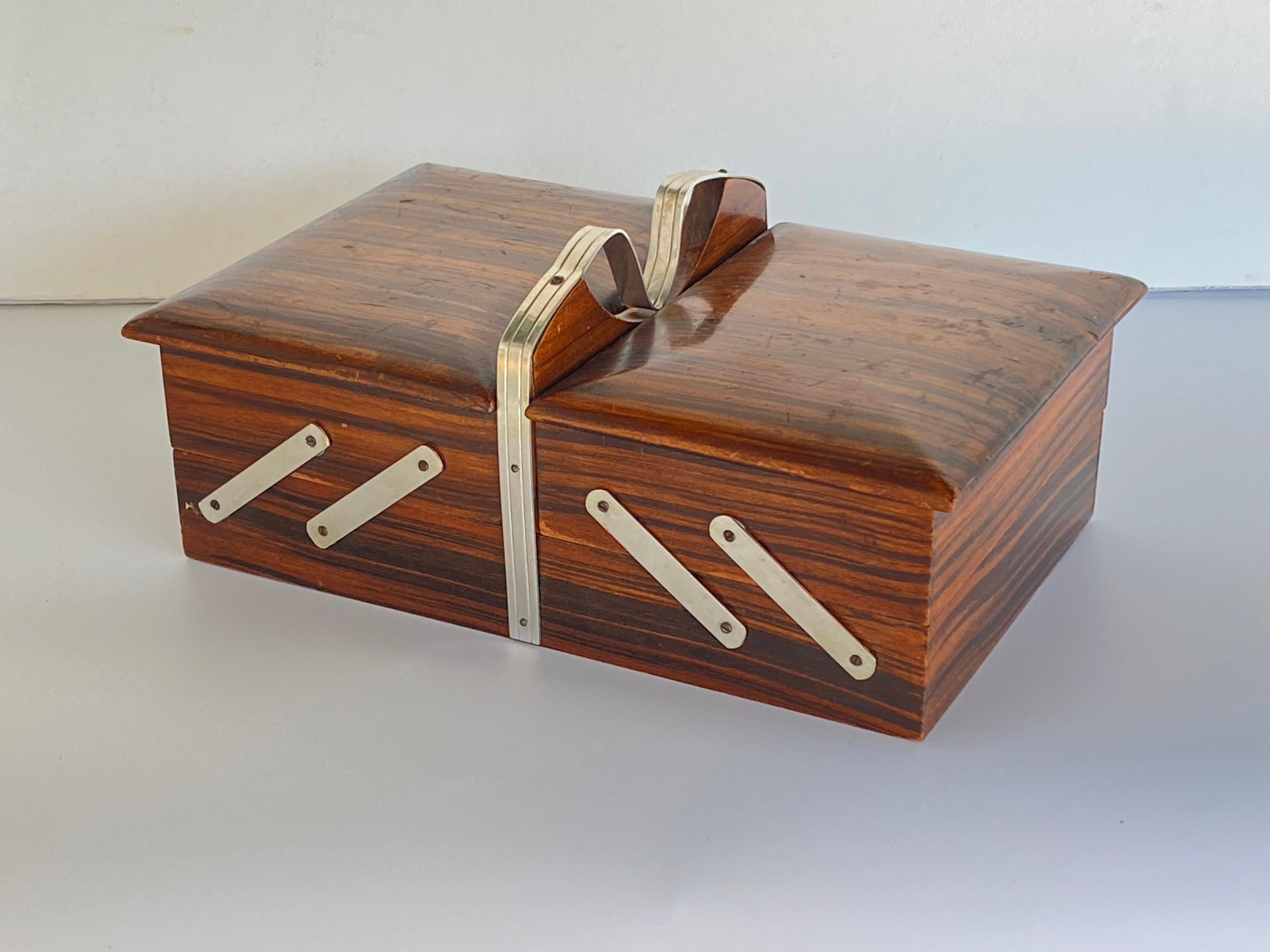 Boîte très rare en ébène de Macassar et bois de satin. C'est une boîte de jeux, qui s'ouvre en articulant les rabats de chaque côté, et qui permet de mettre les nombreux objets de jeux que l'on veut à l'intérieur, elle peut aussi servir à mettre des