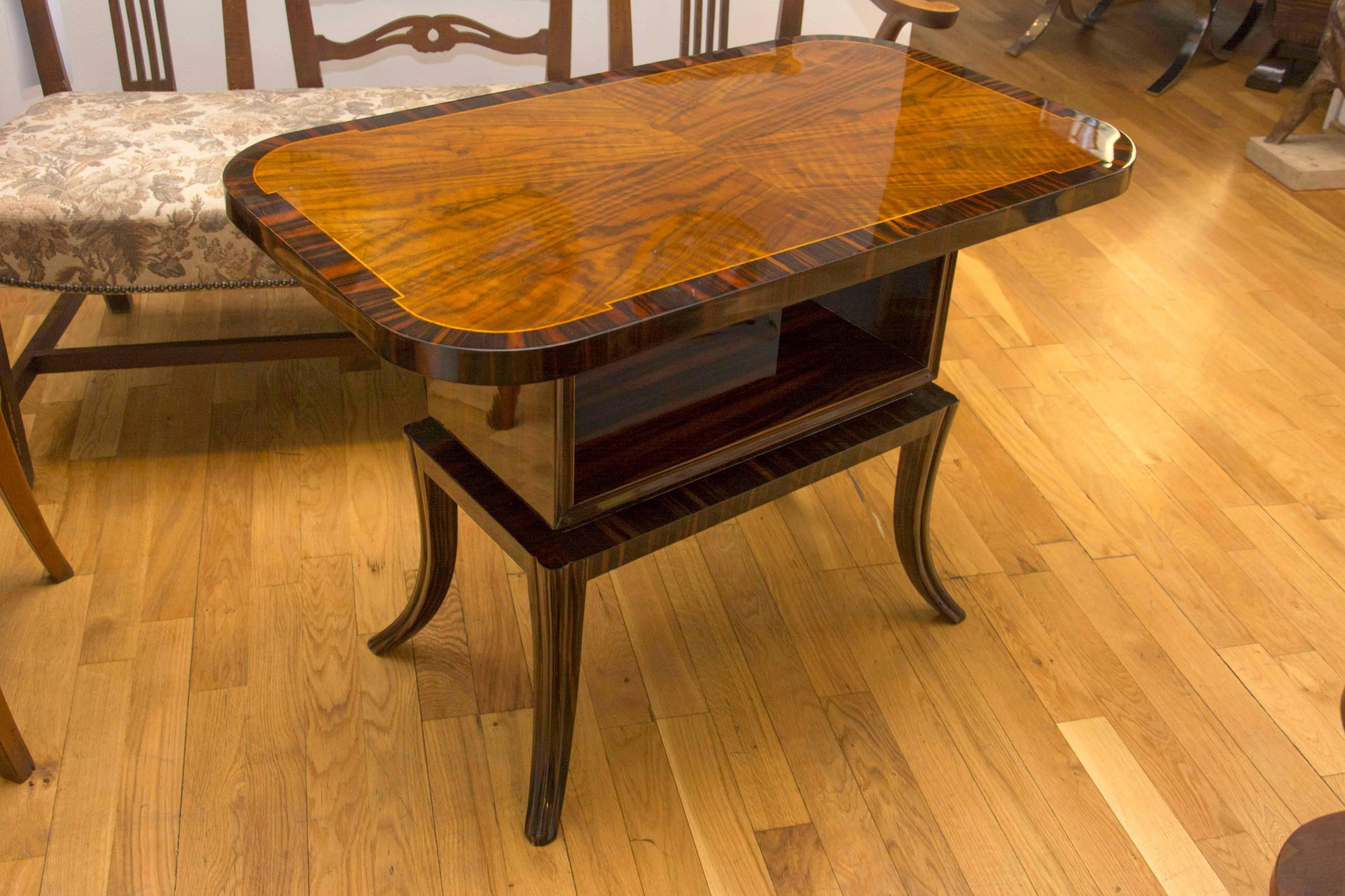 Art Deco Macassar and walnut veneer occasional coffee table, made in the 1930s in Central Europe. It features a storage space for magazines, documents etc. Very elegant design. It has been fully restored and features a high-gloss finish.