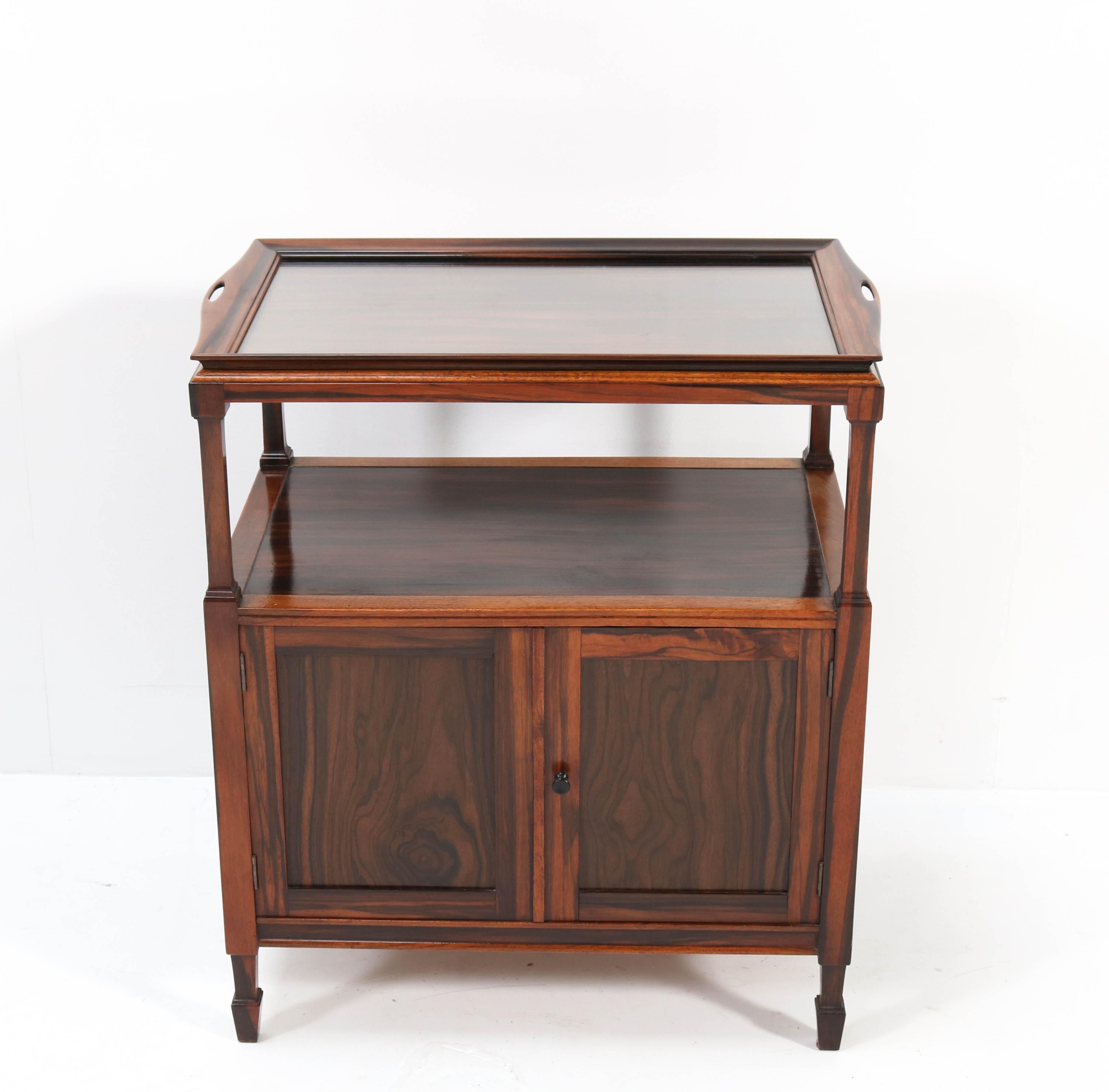 Magnificent and rare Art Deco Amsterdamse School tea cabinet or serving cabinet.
Design by J.J. Zijfers Amsterdam.
Striking Dutch design from the 1920s.
Solid macassar ebony with original serving tray.
Marked with original metal manufacturers
