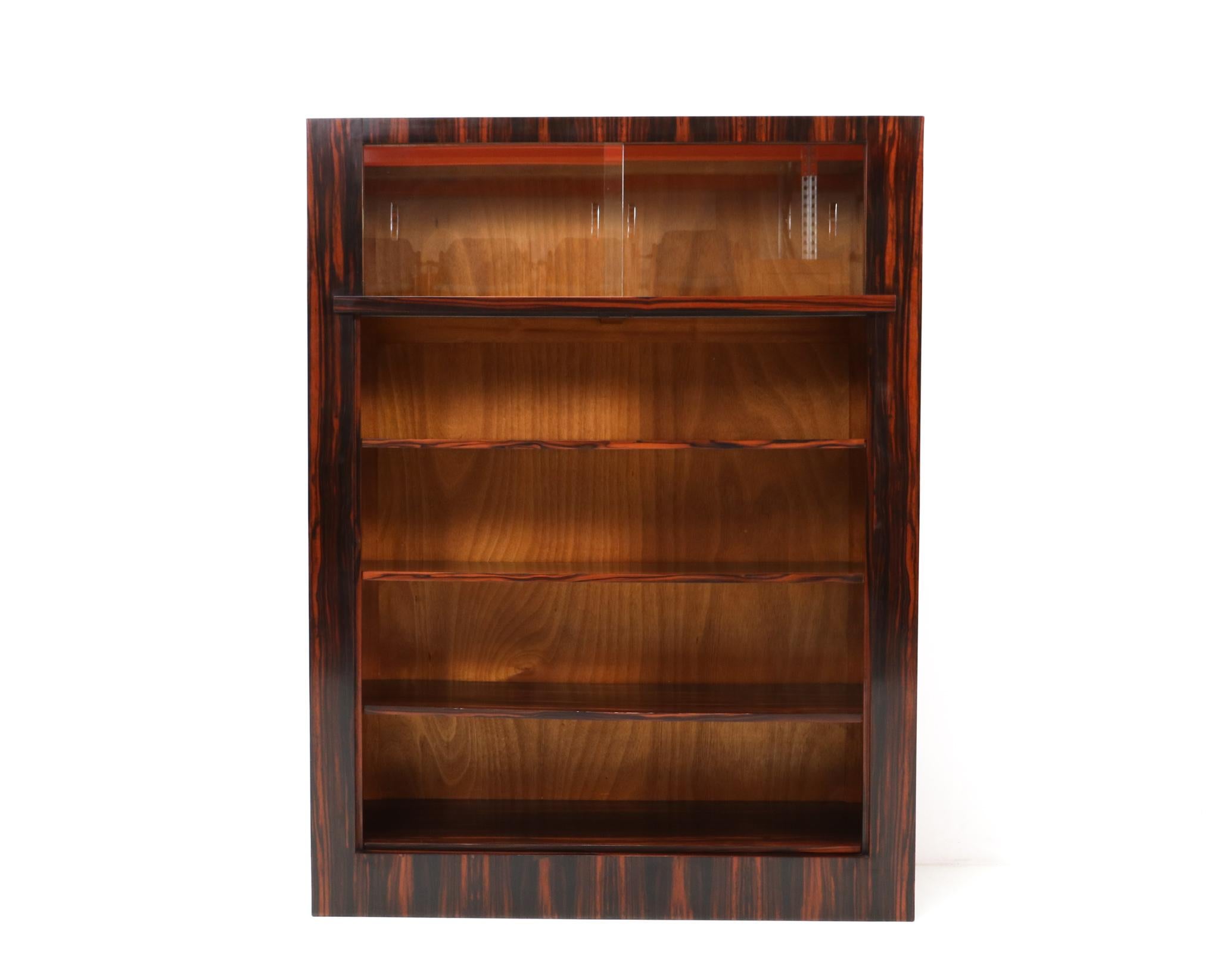 Magnificent and rare Art Deco Modernist bookcase.
Design by Hendrik Wouda for H. Pander & Zonen Den Haag.
Striking Dutch design from the 1920s.
Macassar ebony veneered frame with two original glass sliding doors.
Three original macassar ebony