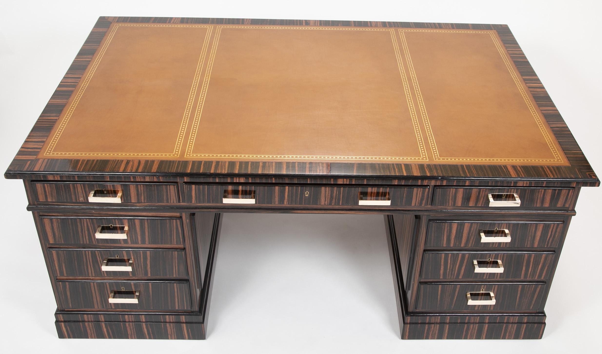 Large nine-drawer Macassar ebony pedestal desk by Waring & Gillow having a red tooled leather top and bronze hardware. Stamped in upper left drawer.

