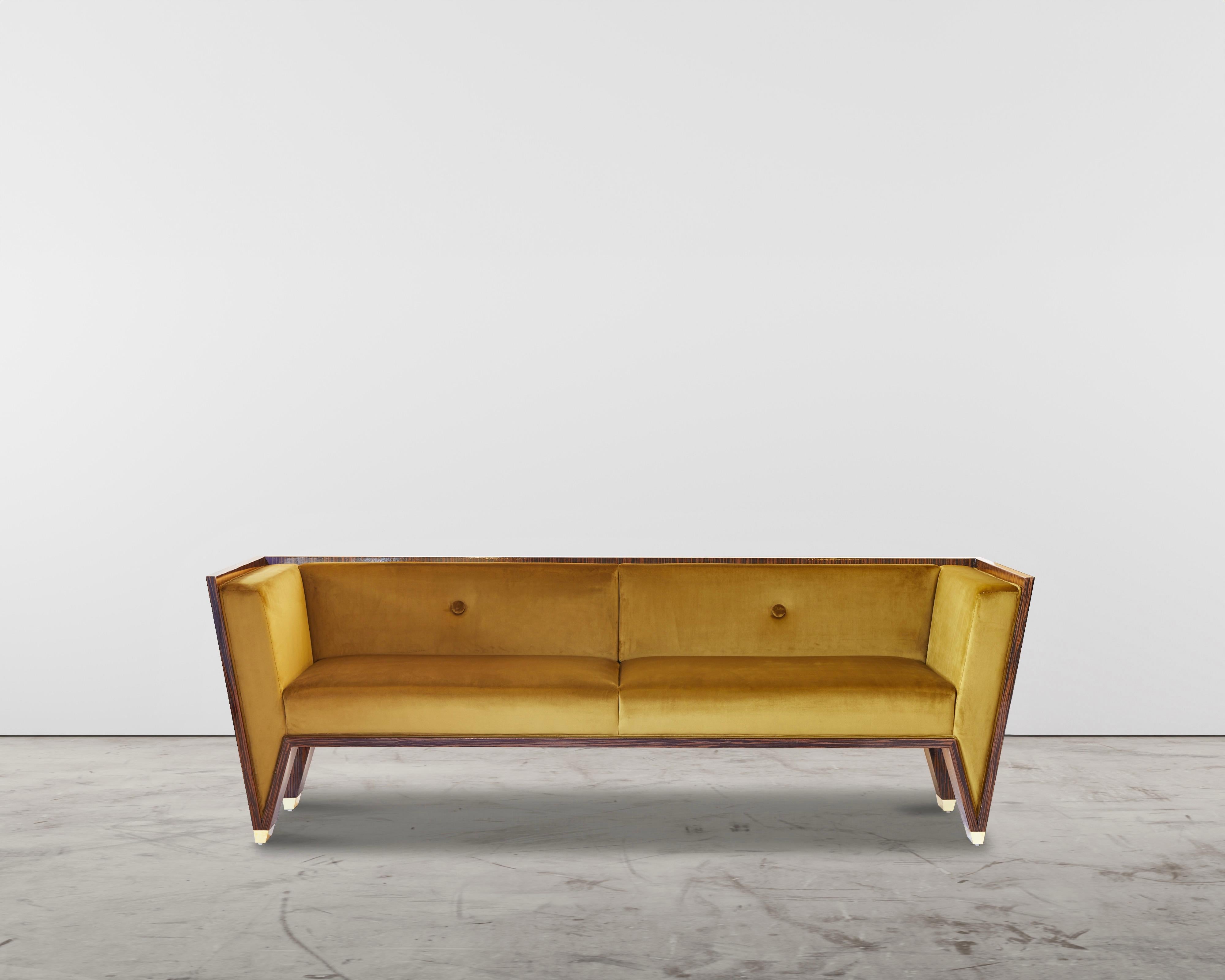 The Wedge Sofa is a timeless handmade contemporary Art Deco sofa. This striking sofa is well-proportioned and bold. The velvet is like butter and Macassar Ebony has a high gloss lacquer finish. The feet are made out of solid brass and have a mirror