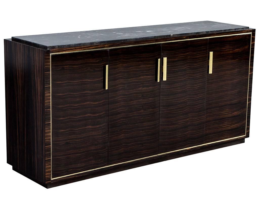Macassar marble-top buffet sideboard custom-made by Carrocel, this sideboard is made of exotic Macassar Ebony wood. It is hand polished to a rich deep, gloss patina. Featuring inset brass trim and hardware to further accentuate the clean lines of
