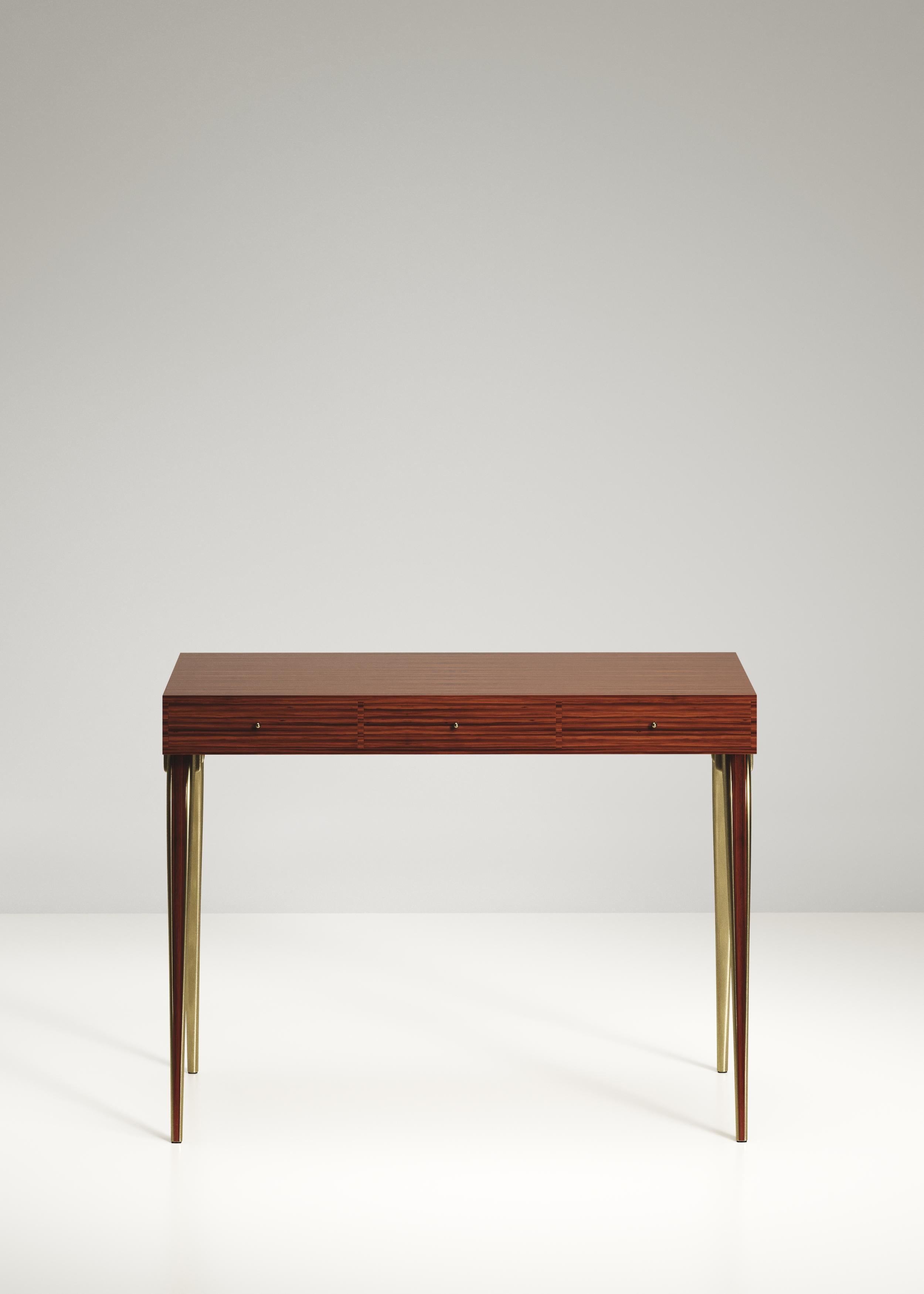 Lo scrittoio Sonia è il pezzo perfetto per la tua stanza. Versione più discreta della sorella, l'iconico scrittoio, Sonia ha eleganti gambe intarsiate in legno di Macassar e ottone bronzo-patina. Aggiungi uno specchio e questa scrivania diventerà un