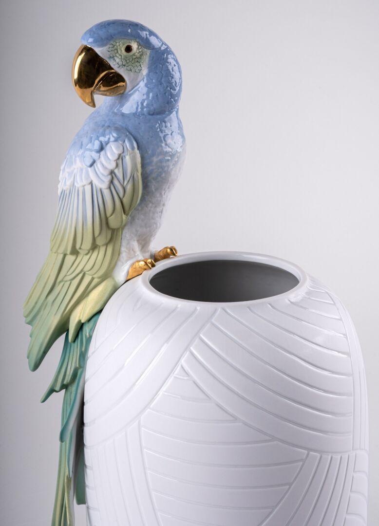 Porcelain vase in simple lines with a macaw decorated in blue, green and iridescent tones. The brand’s series of vases is expanded with this new addition featuring a macaw with gilded beak and claws. The exquisite treatment of the bird and the