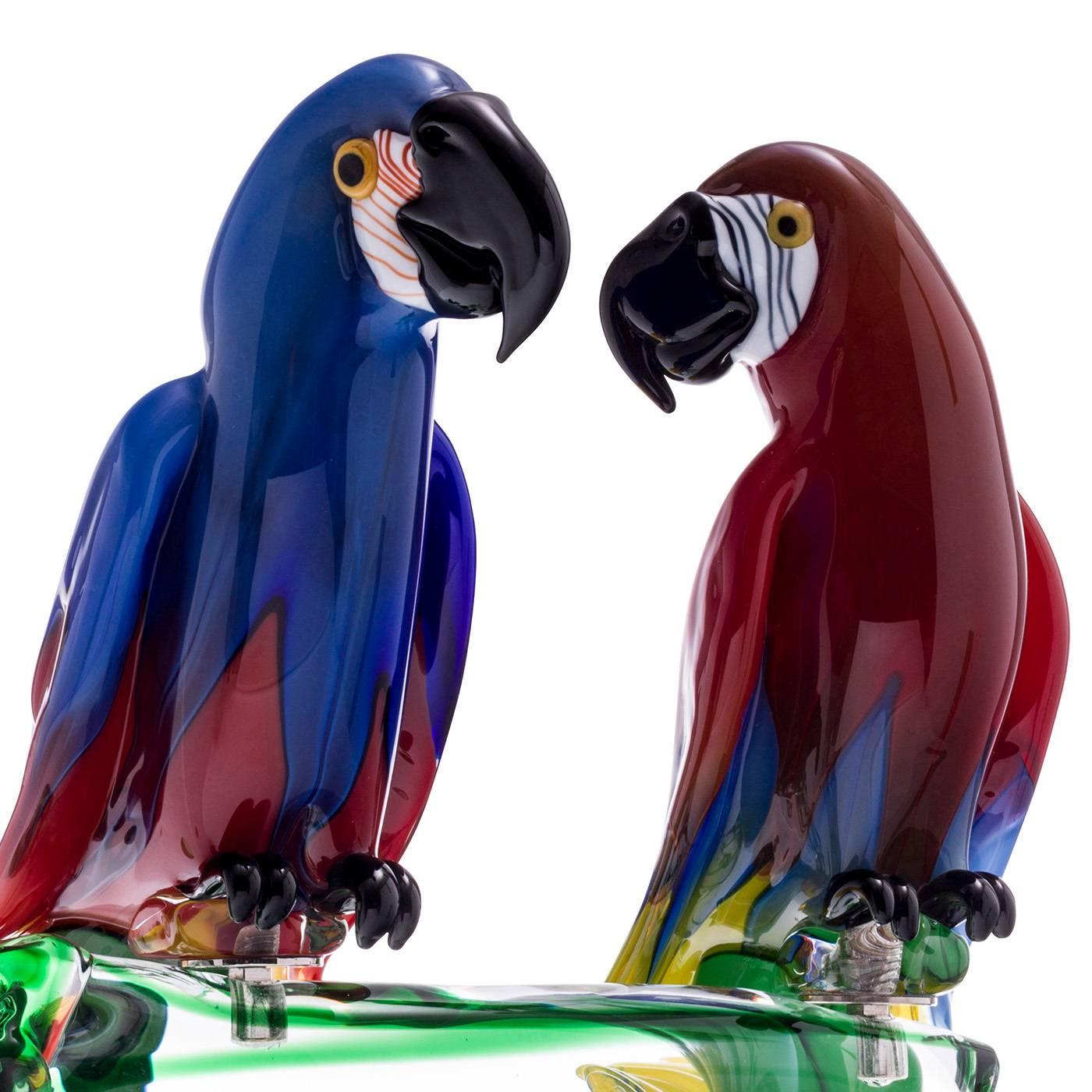This couple of exceptional Macaw Parrots are made by the master glass blower Zanetti on the island of Murano in Venice. Remarkably animated and colorful, these birds are made of solid glass and perch on a clear glass branch pedestal. The birds have