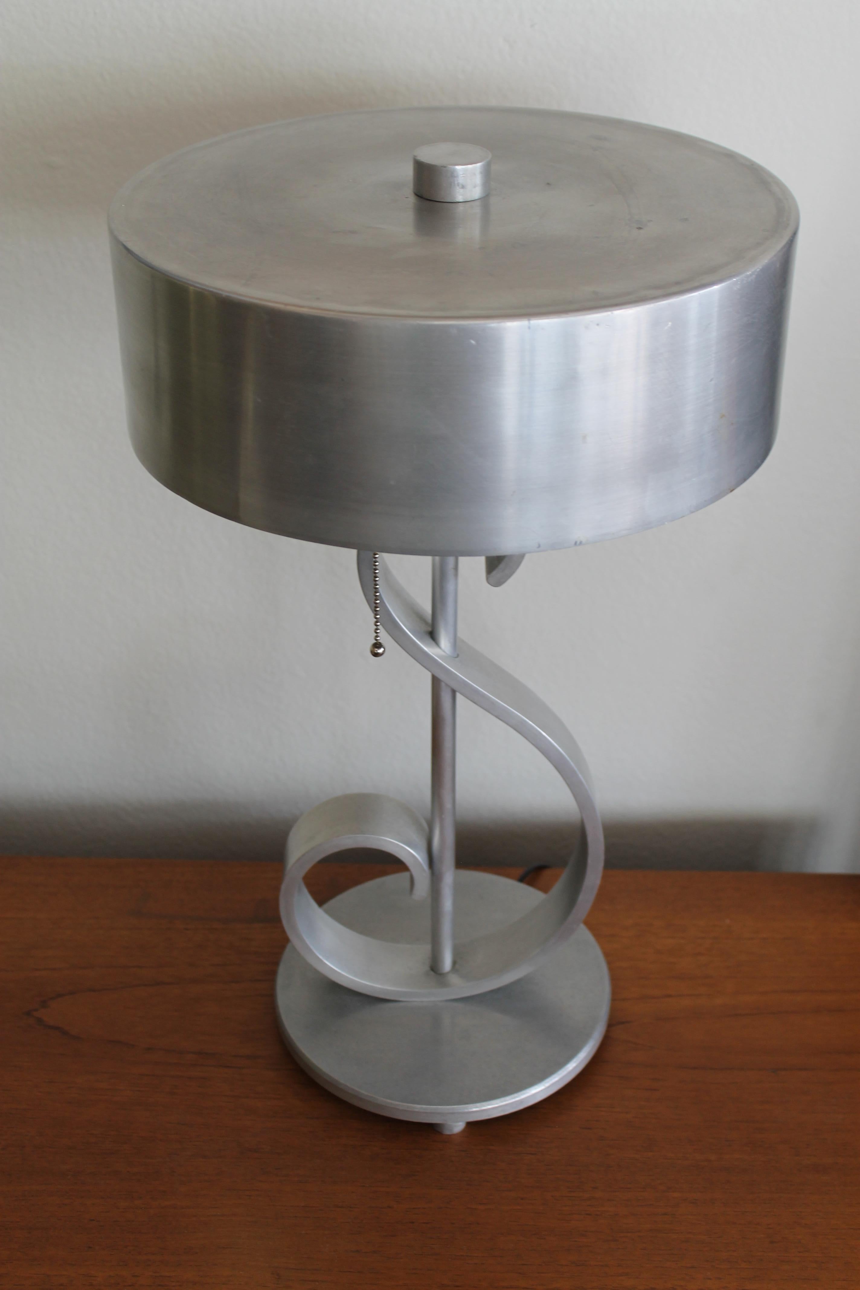 Aluminum musical note table lamp with original shade and finial. Lamp has been professionally rewired with an in-line switch and pull chains. Lamp (with shade) measures 20.5