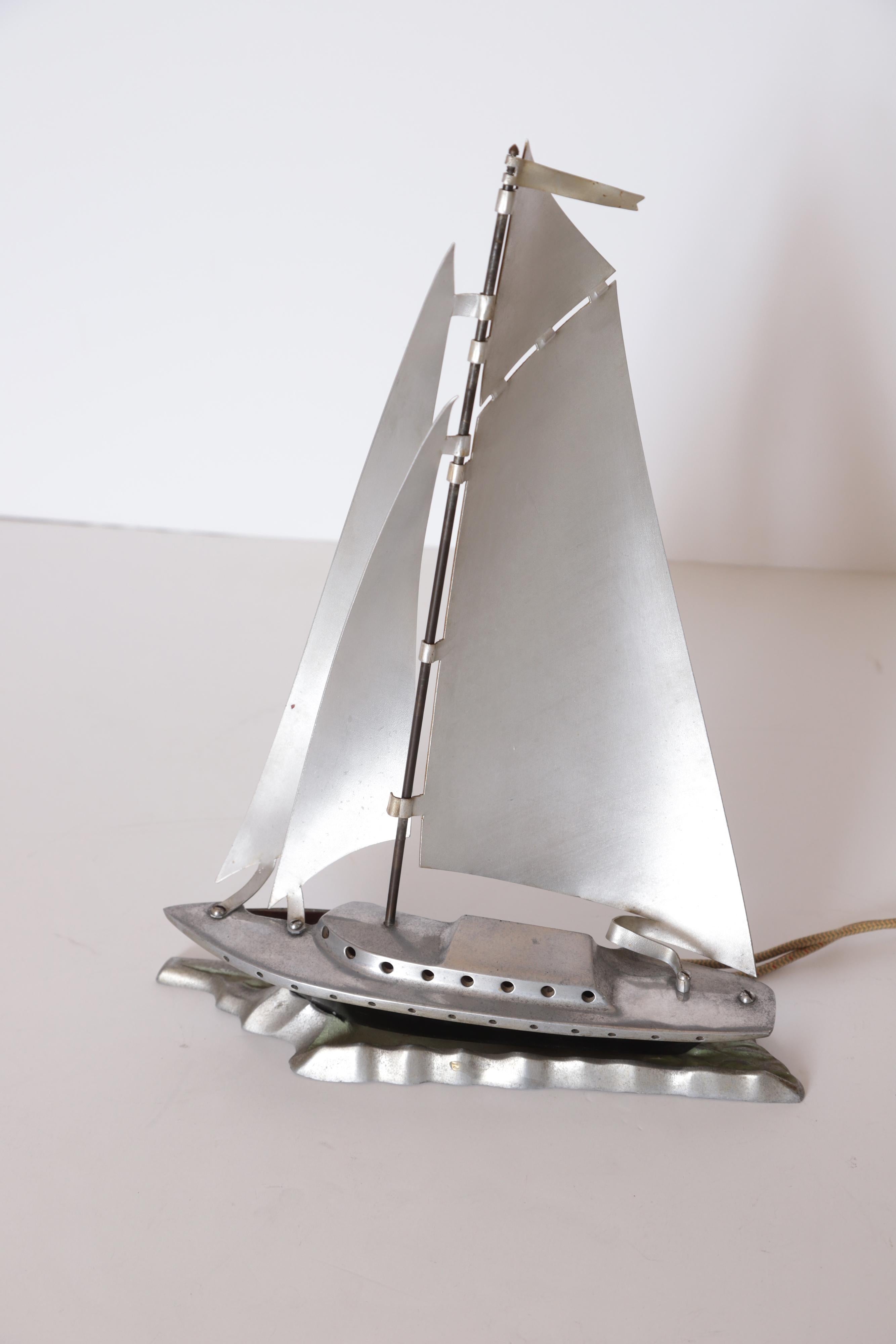 Machine Age Art Deco Streamline Aluminum Sailboat Night Light / Mood Lamp    Table Lamp  Boat Ship

Vintage Aluminum Sailing Vessel Decorative Lamp ca 1930's.
One-piece cast aluminum deck & cabin, with attached silver anodized aluminum sails.