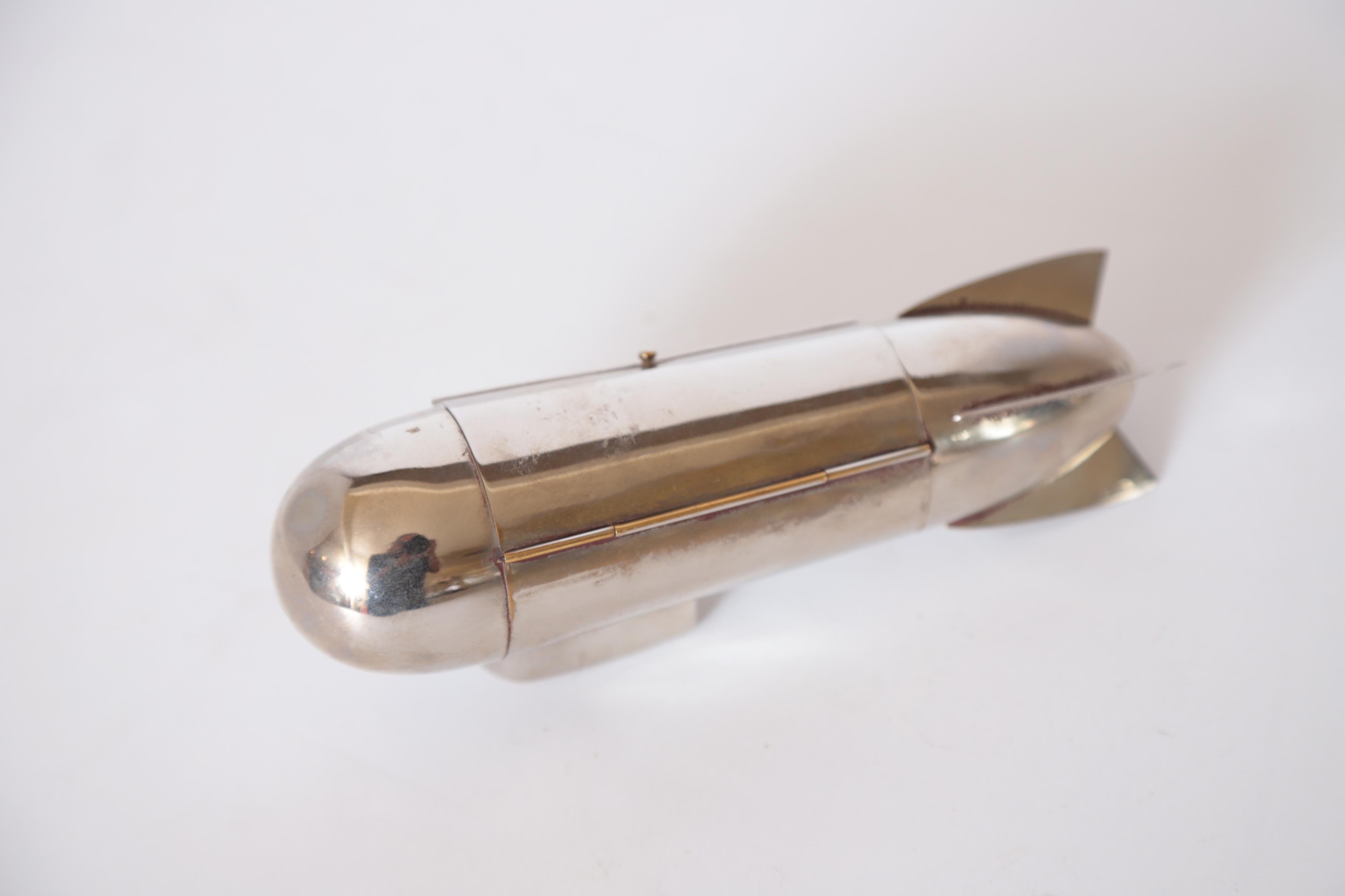 Machine Age Art Deco chrome Zeppelin cigarette holder or trinket box

Similar design to the Henkels / DRGM German cocktail shakers and cigar holders. No apparent signature.
Hinged lid opens to reveal internal compartment for most likely