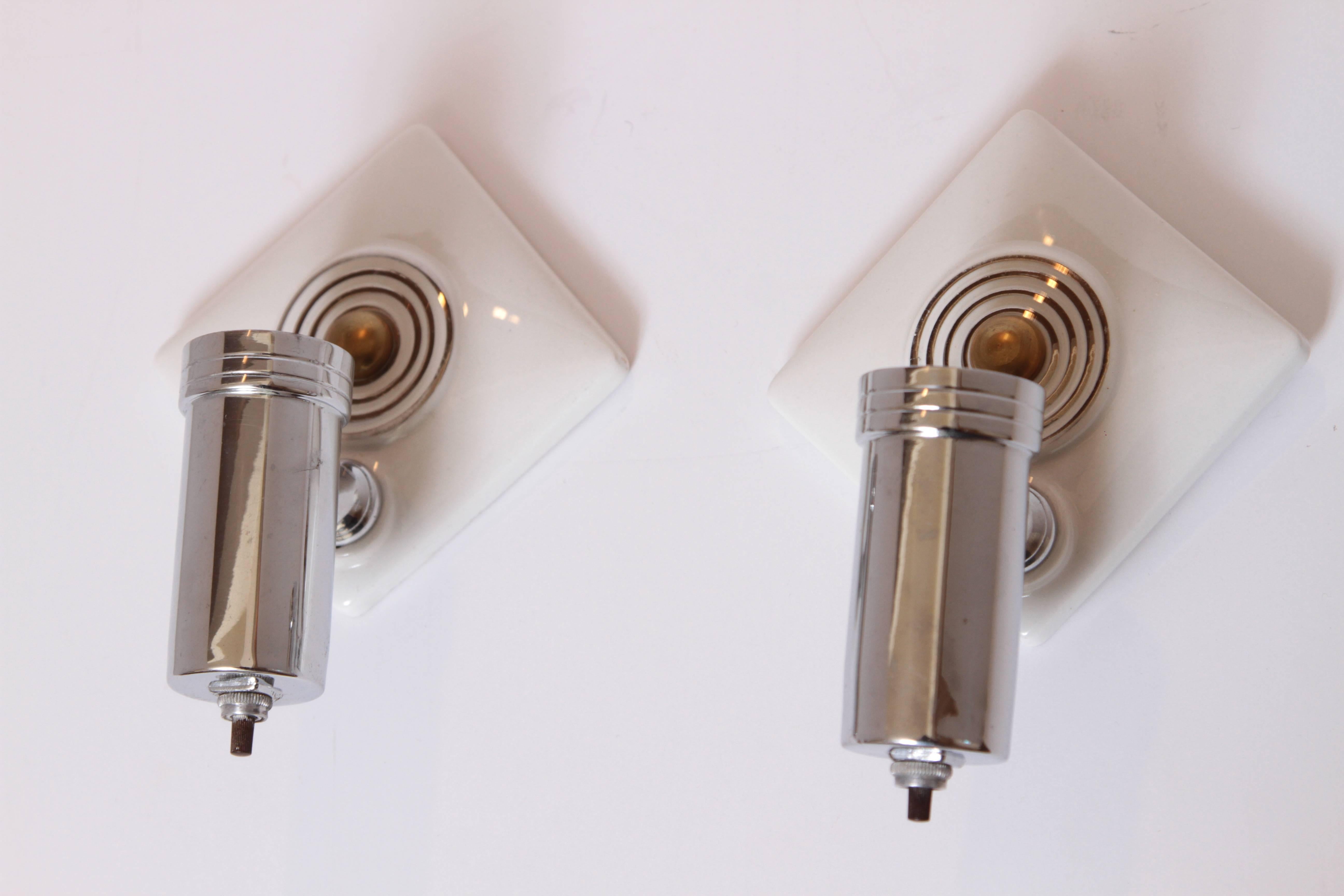 Pair of Machine Age Art Deco Efcolite skyscraper sconces by Walter Von Nessen.

One of Nessen's iconic early 1930s designs for Efcolite.
Original lustrous milky white glaze with applied platinum-fired concentric rings and chromed
