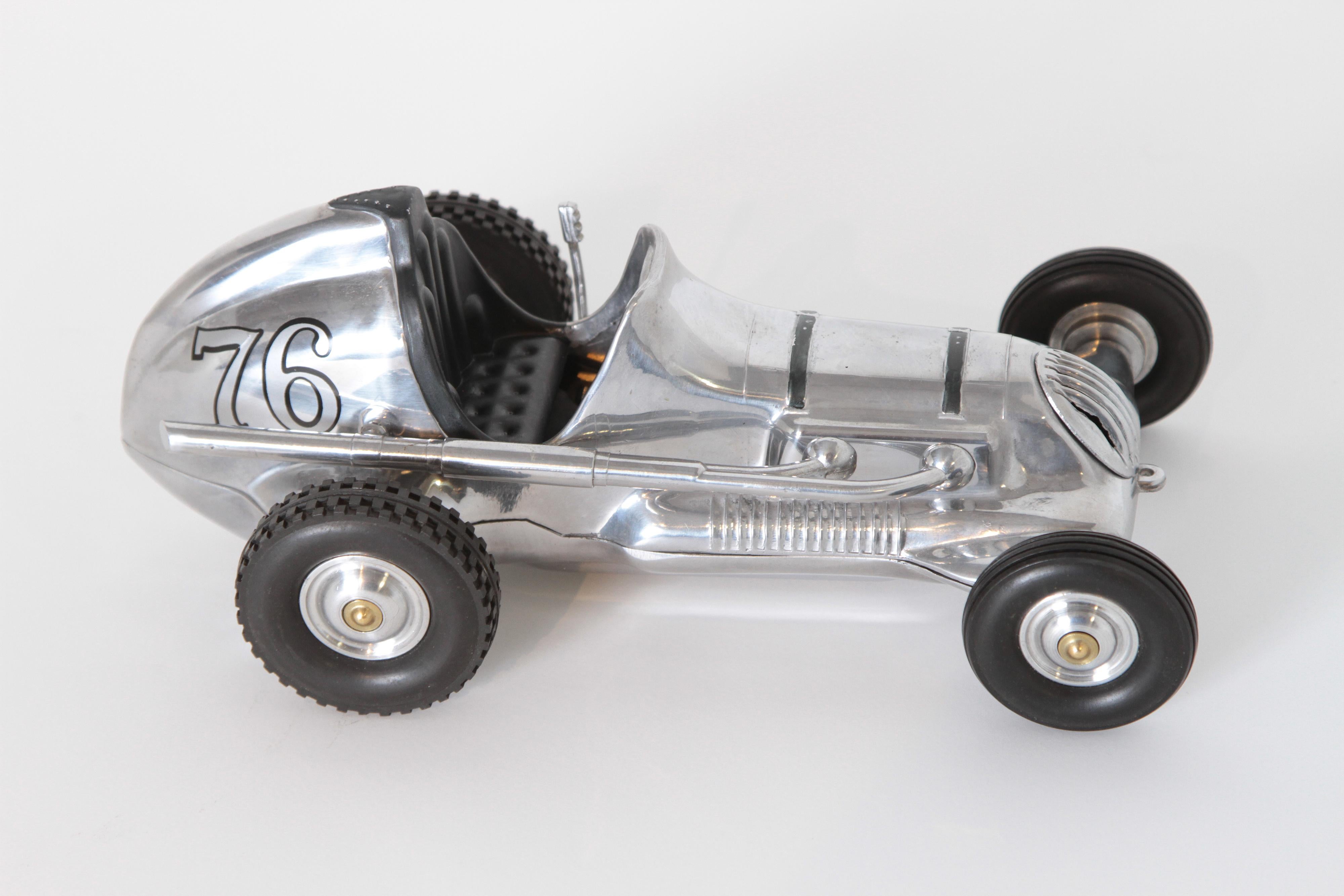 Machine Age Art Deco Roy Cox Thimbledrome polished aluminium tether / push car

Minty vintage Champion model push car; minimal use, original tires, exhaust and handbrake.
Highly polished cast aluminium body, machined aluminium hubs, rubber