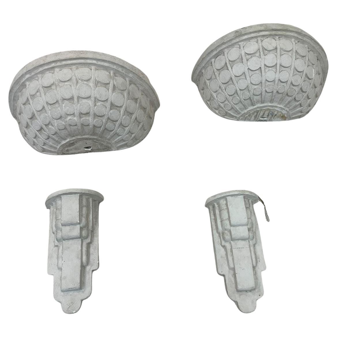 Incredible large-scale plaster Art Deco sconces. Beautiful design with geometric circles and a skyscraper base. Pieces have minor chips and wear. Each sconce is made up of two pieces and both need to be rewired. Would also look amazing as planters.