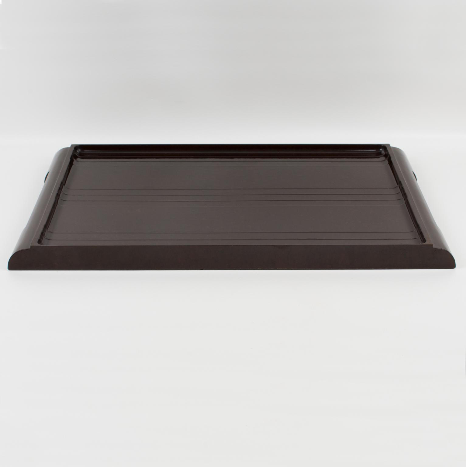 This lovely English Art Deco Machine Age serving tray is made of brown marble Bakelite and was produced during the 1920s period. The large butler shape has molded handles on the sides. Its dimensions make it perfect for barware, cocktail serving, or