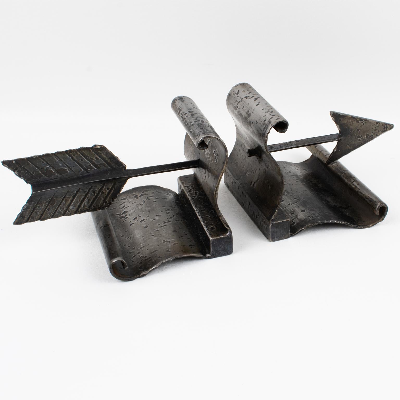 These stunning Machine Age Art Deco bookends were crafted in France in the 1940s. The wrought iron metal has an Industrial feel and features a crossing arrow. The original black-gunmetal patina has a textured pattern on the metal. These sturdy