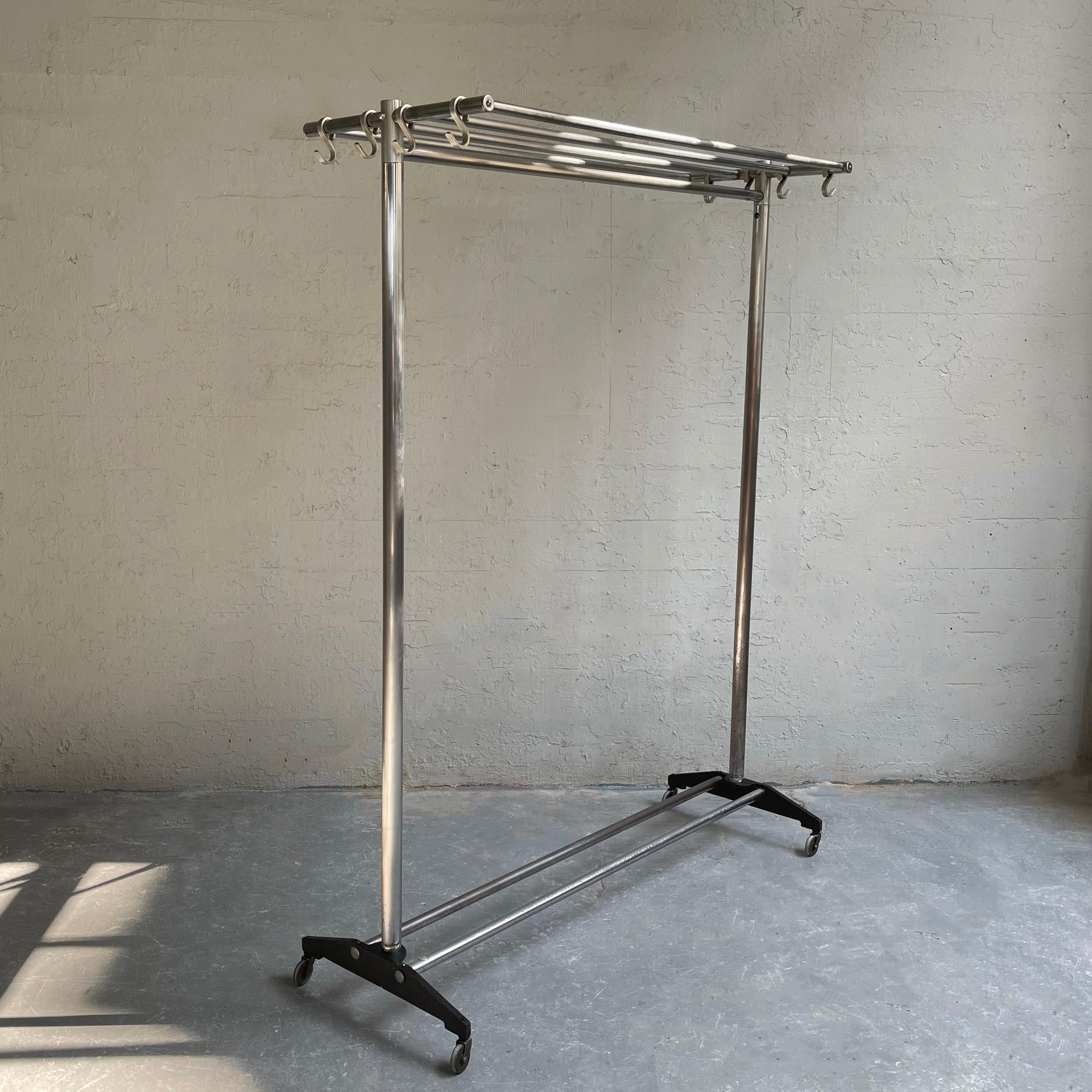 Machine-age, midcentry, steel and chrome plated steel, rolling garment rack features a tubular slat top shelf with 